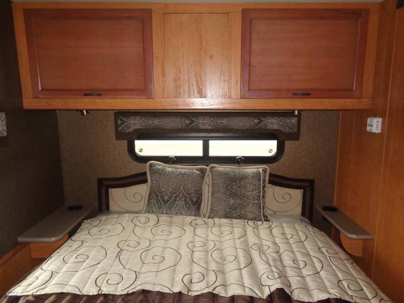 Experience an RV rental bedroom with a comfortable bed, convenient overhead storage, and compact side shelves.. Holiday Rambler Admiral 2016