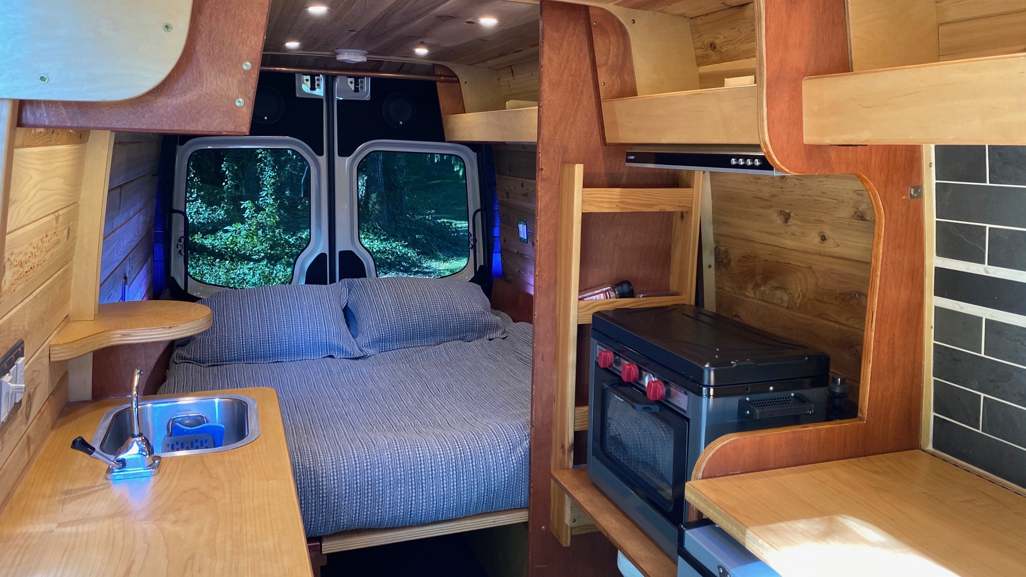 Step inside this RV rental! Comfortable bed, functional kitchen with sink, and portable oven. Enjoy the forest view.. Mercedes-Benz Sprinter 2008