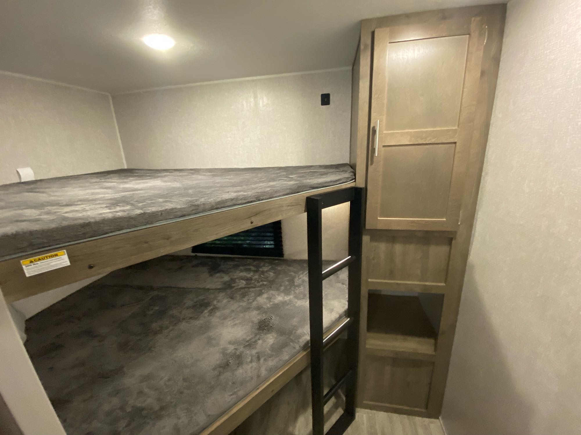 RV rental bunk beds offer compact sleeping. Cozy interior features a cabinet and ladder.. Dutchmen Aspen Trail 2020