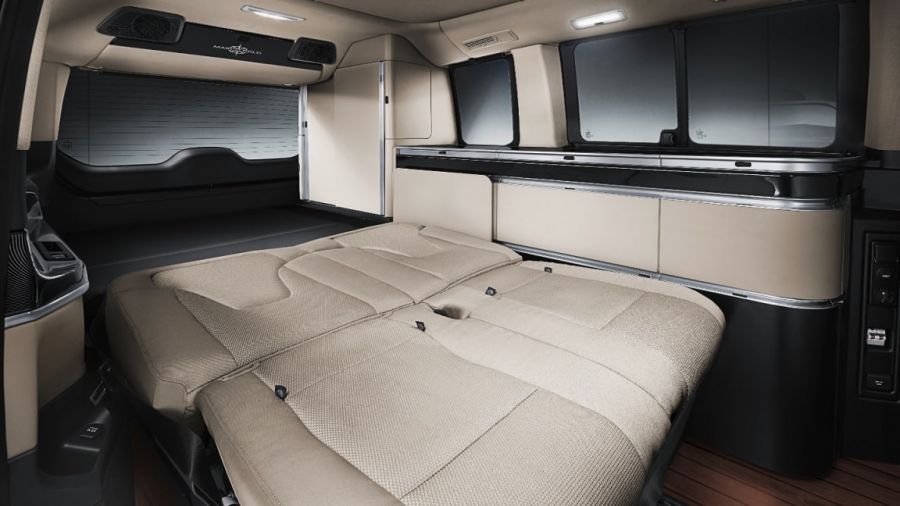 Inside a modern RV rental: rear seats fold into a spacious bed, with ample side storage & windows for comfortable travel.. Mercedes Class V Marco Polo 2021