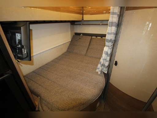 RV rental interior: cozy bedroom featuring a comfortable bed, wall-mounted TV, and light-colored walls.. Winnebago View 2019