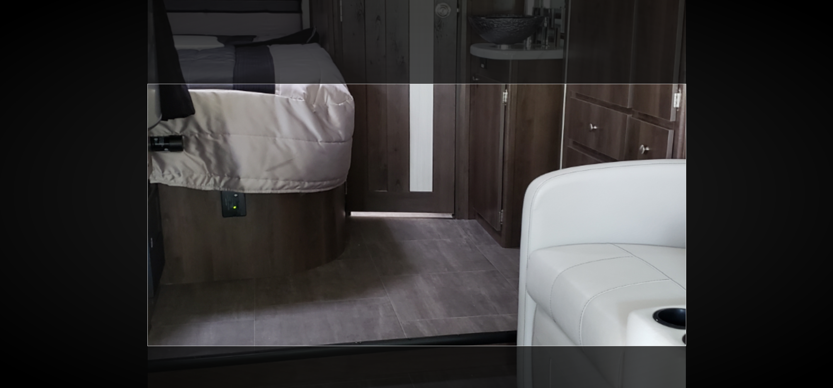 RV rental interior features a cozy bed, modern wood cabinetry, and comfortable seating on a sleek tile floor.. Coachmen Prism 2018