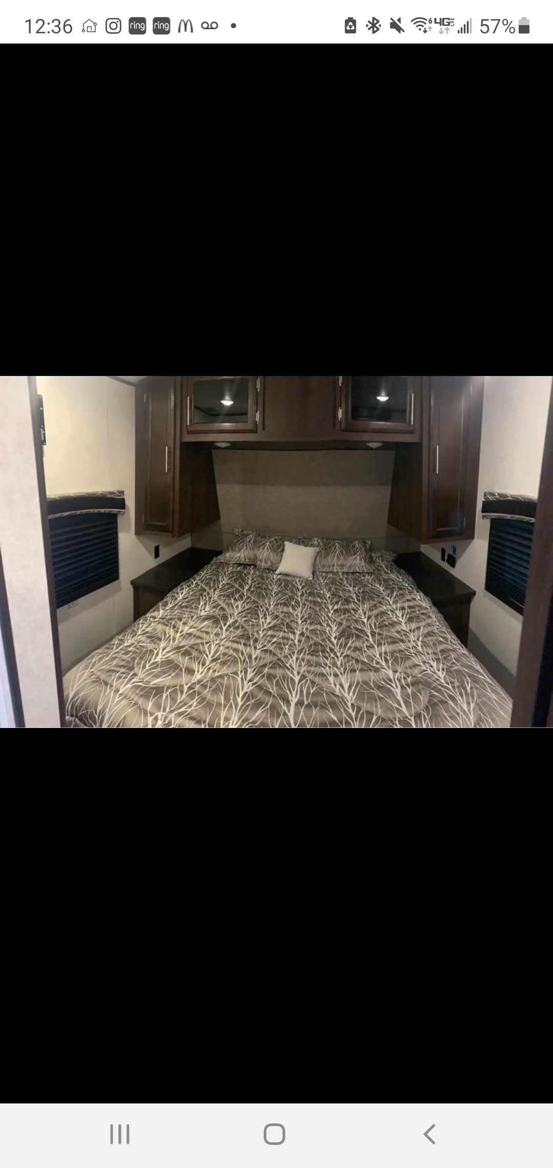 Inside an RV rental: a well-appointed bedroom with a large bed, dark wood cabinets, and window blinds.. Jayco Jay Flight 2019