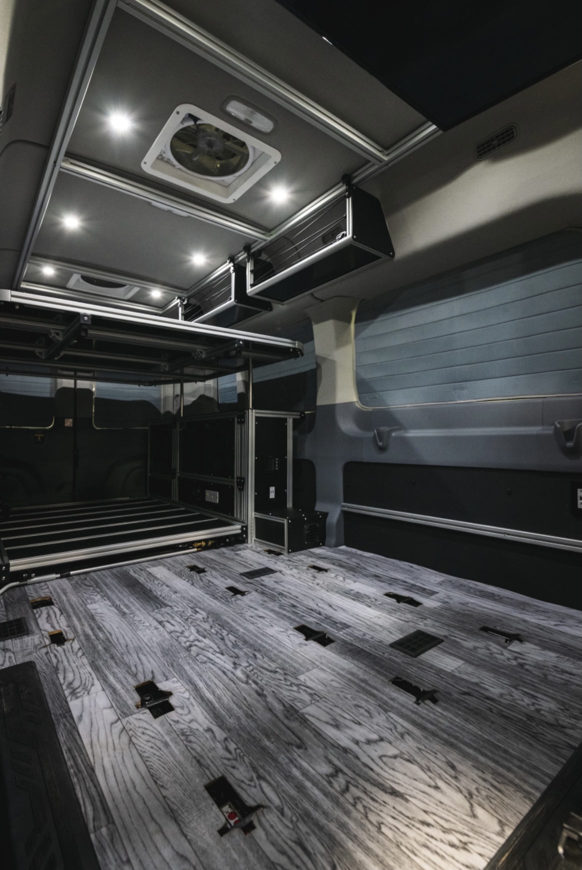 Modern RV rental interior: wood-look floor, elevated bed platform, overhead storage, and bright LED lighting.. Other Vandoit LIV 2019