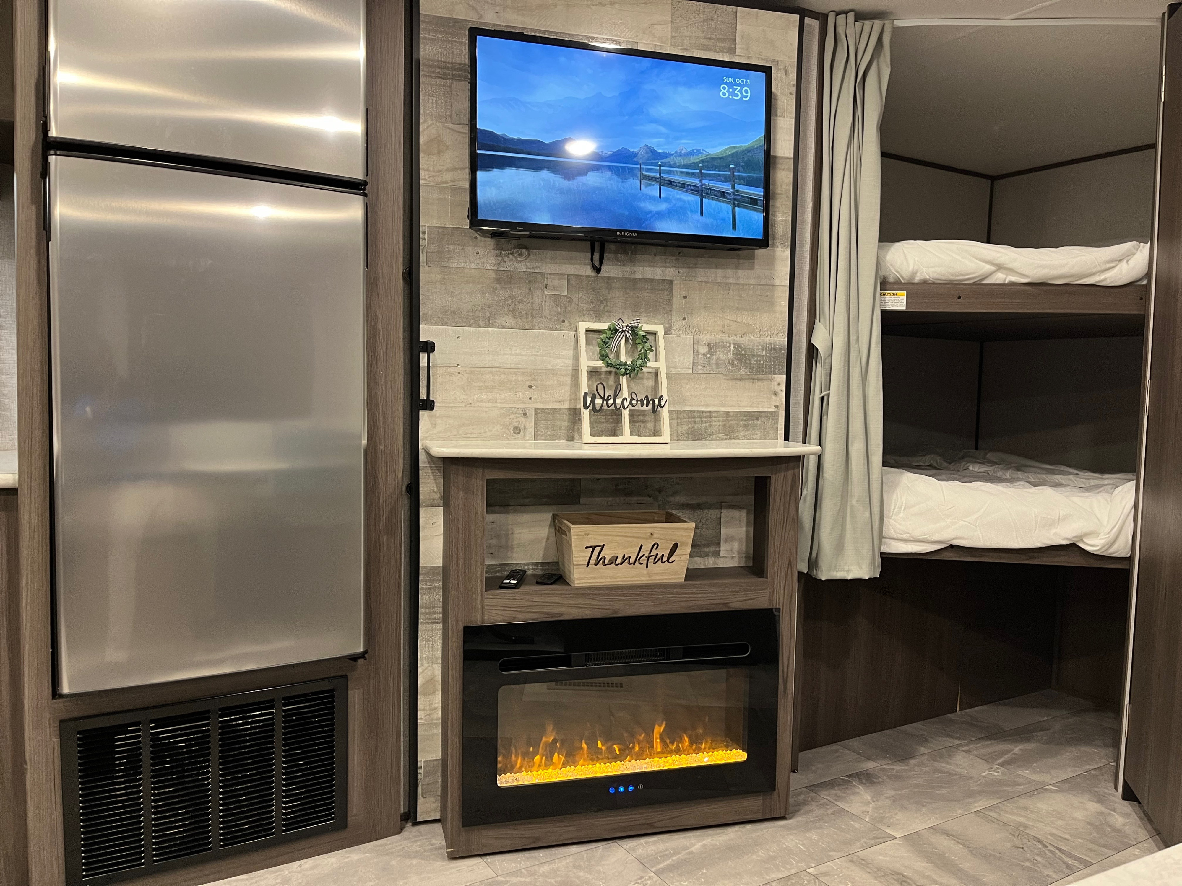 This inviting RV rental features a modern interior with a fridge, wall-mounted TV, electric fireplace, and built-in bunk beds.. Dutchmen Kodiak 2021