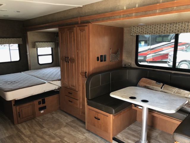 Inside this **rv rental**: a cozy dinette, wardrobe, and convertible sleeping area. Perfect for your road trip comfort.. Forest River Sunseeker 2017