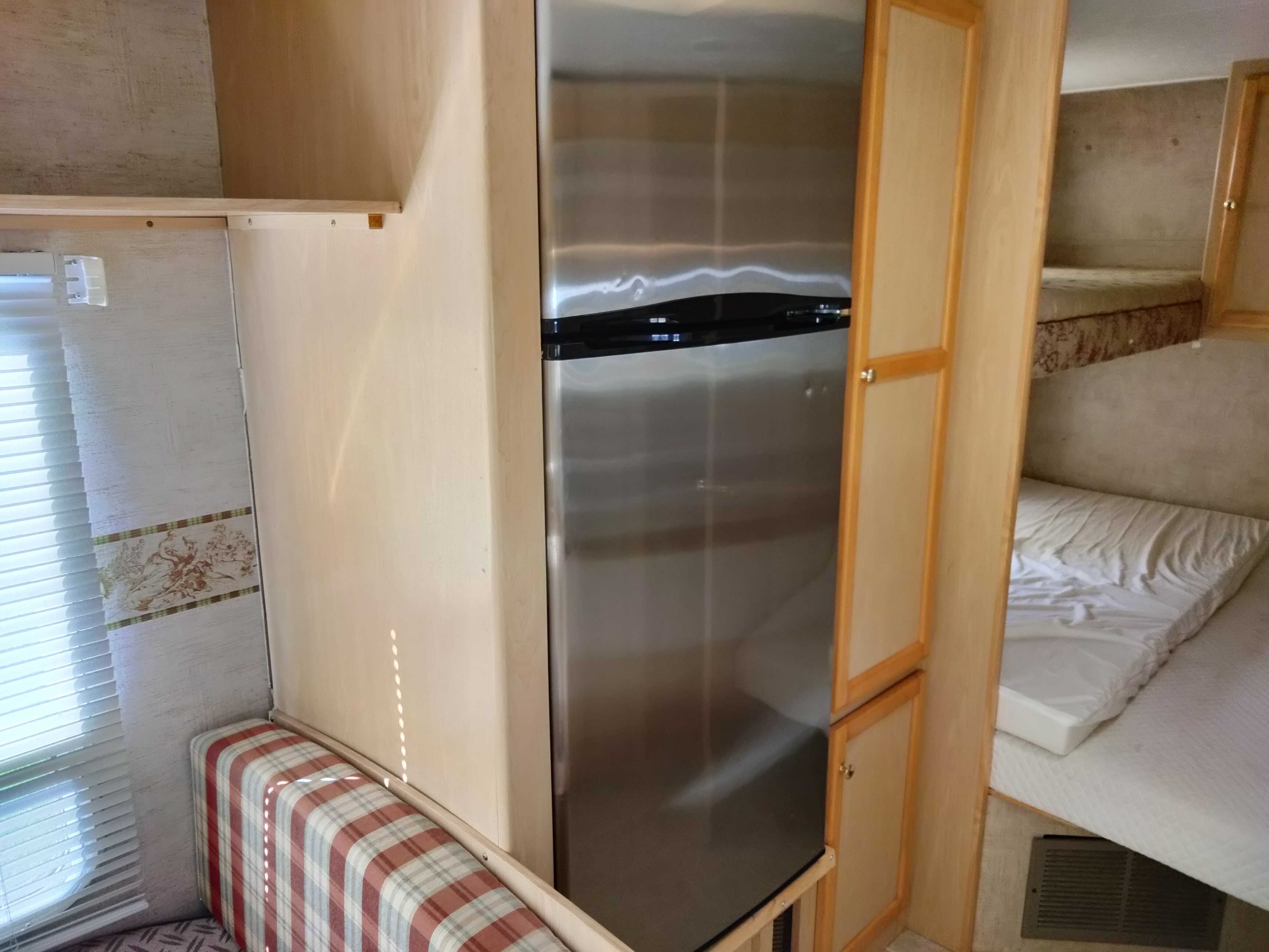 Spacious RV rental interior featuring a modern stainless steel refrigerator, cozy dinette, and bunk beds.. Jayco Jay Feather 29M 2005