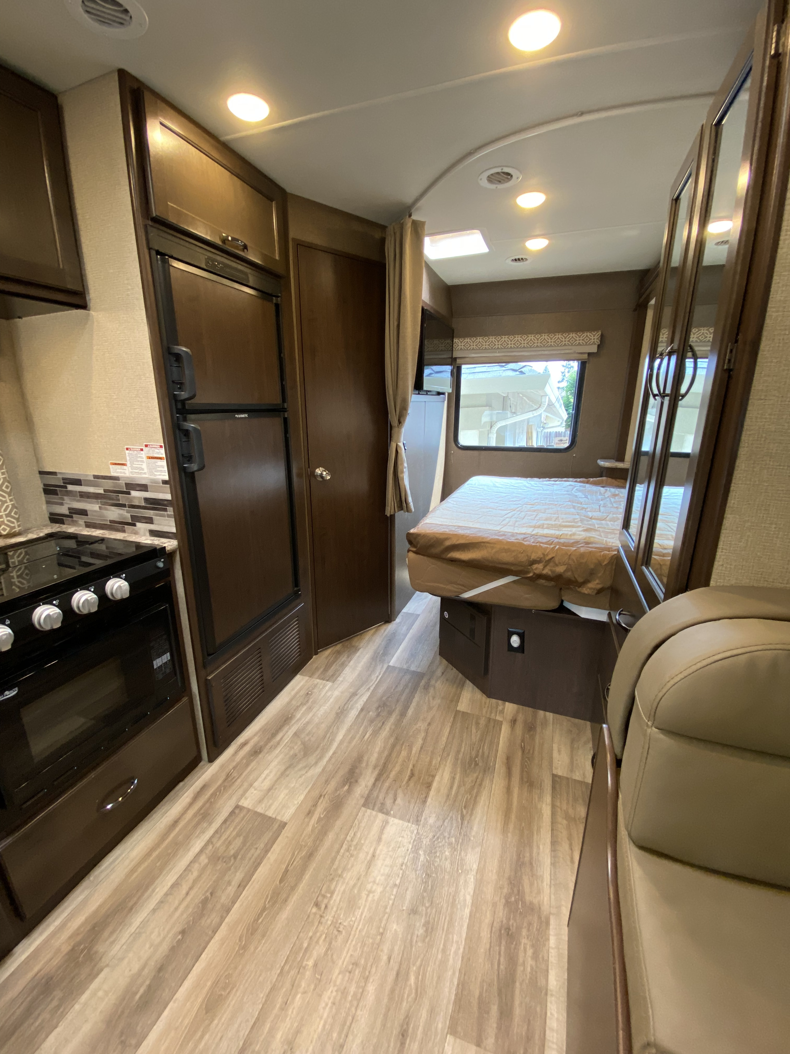 Discover the cozy and functional interior of this RV rental, complete with a kitchen, bed, and seating.. Thor Motor Coach Freedom Elite 2019