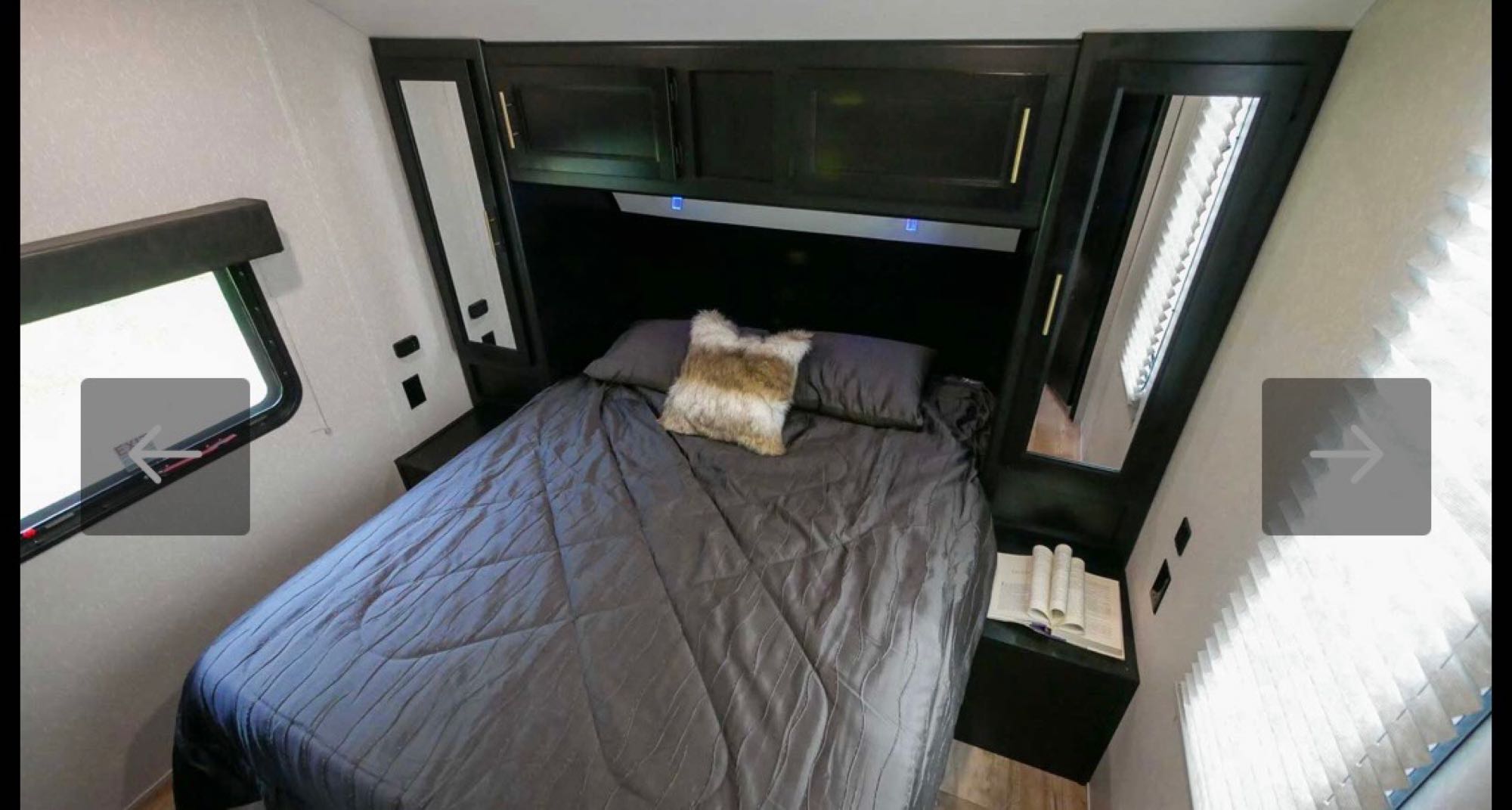 Cozy modern RV rental bedroom interior featuring a comfortable bed, overhead storage, and windows, ideal for travel.. Forest River Cherokee Grey Wolf 2021