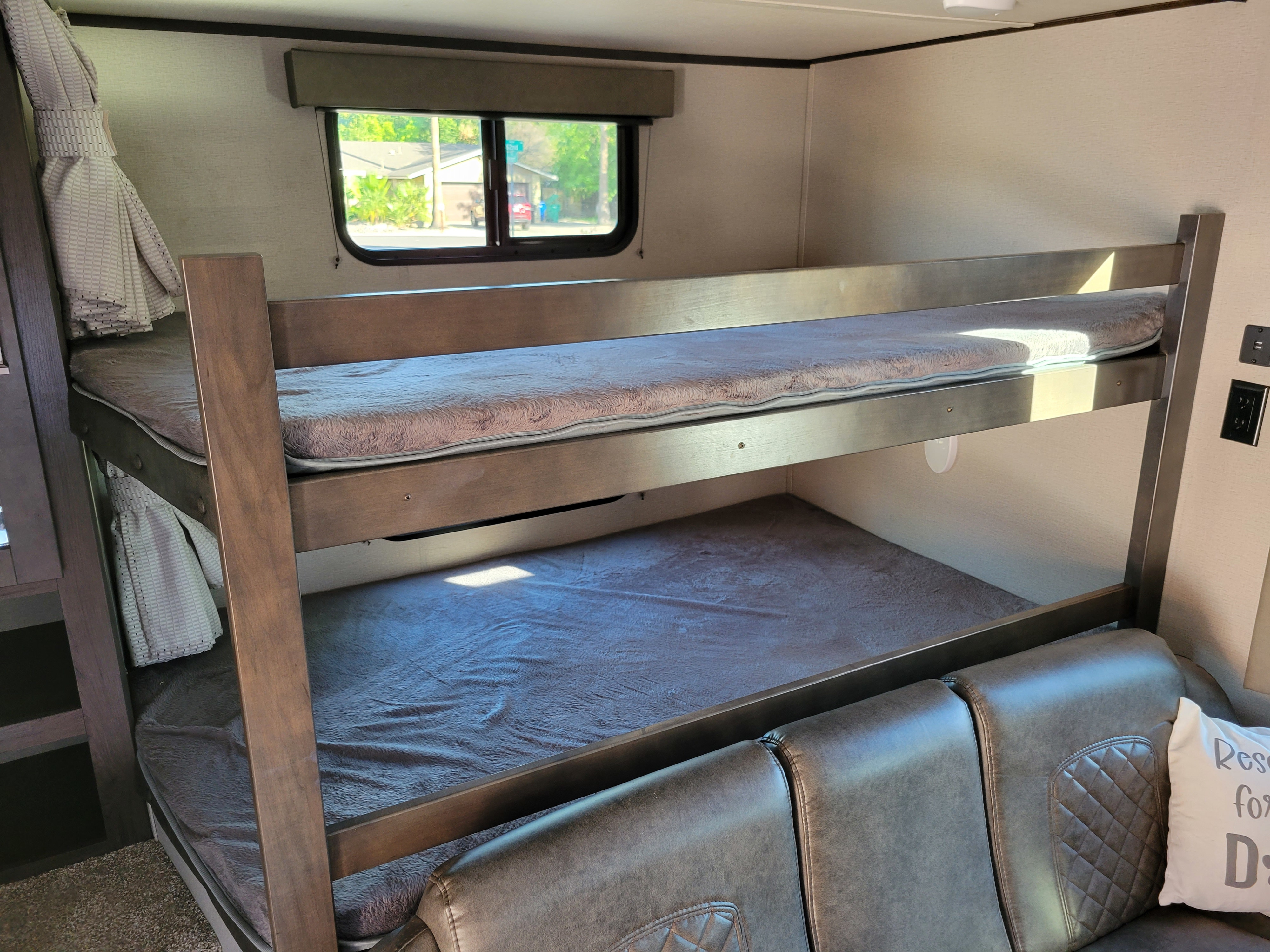 RV rental: Bright, modern interior featuring stacked bunk beds, a plush sofa, and a window view.. Grand Design 265bh 2021