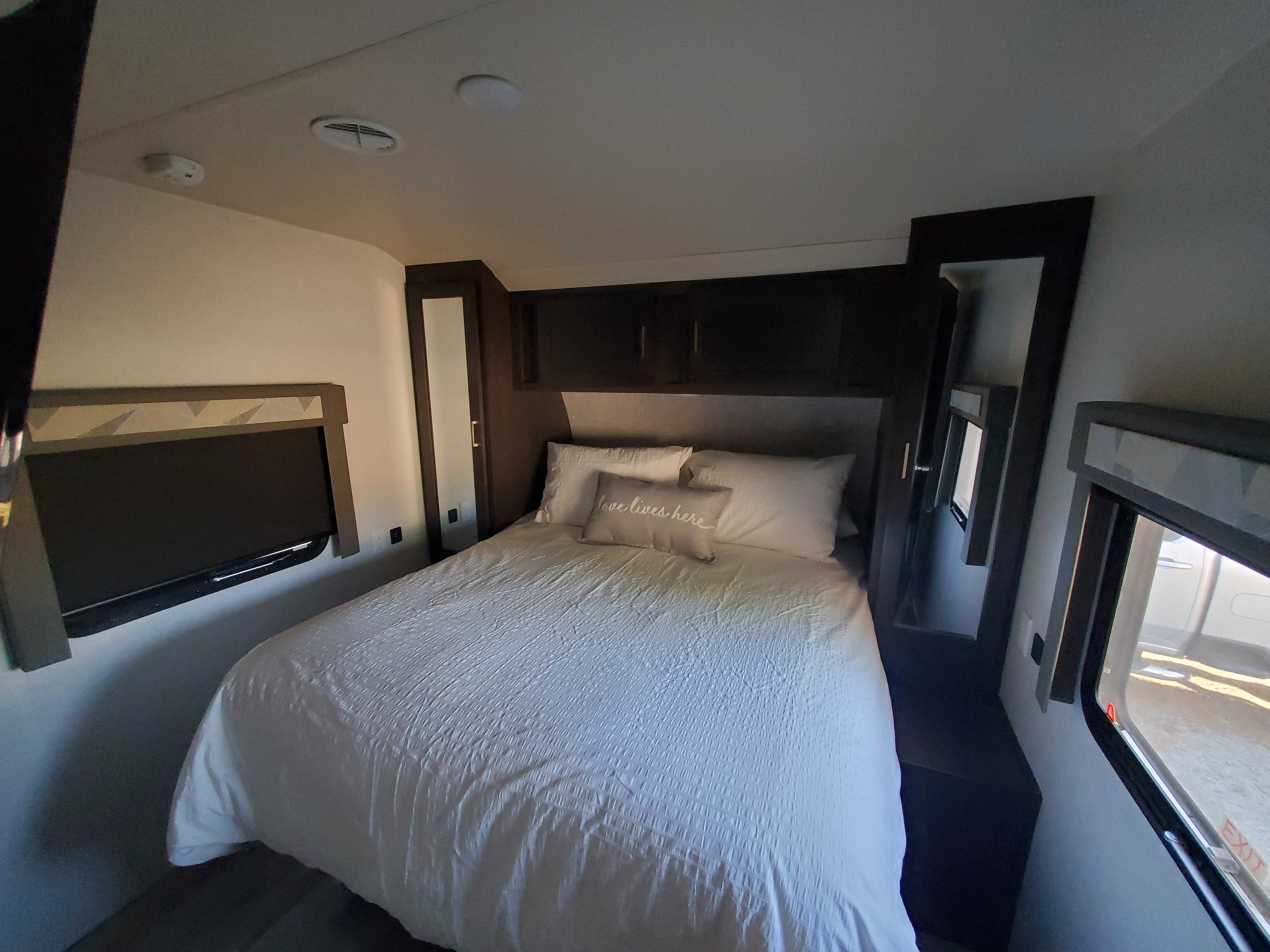 Comfy Queen bed with walk around access and closet.  Wake up with a view of the river when staying in a waterfront site.. Forest River Wildwood 2019