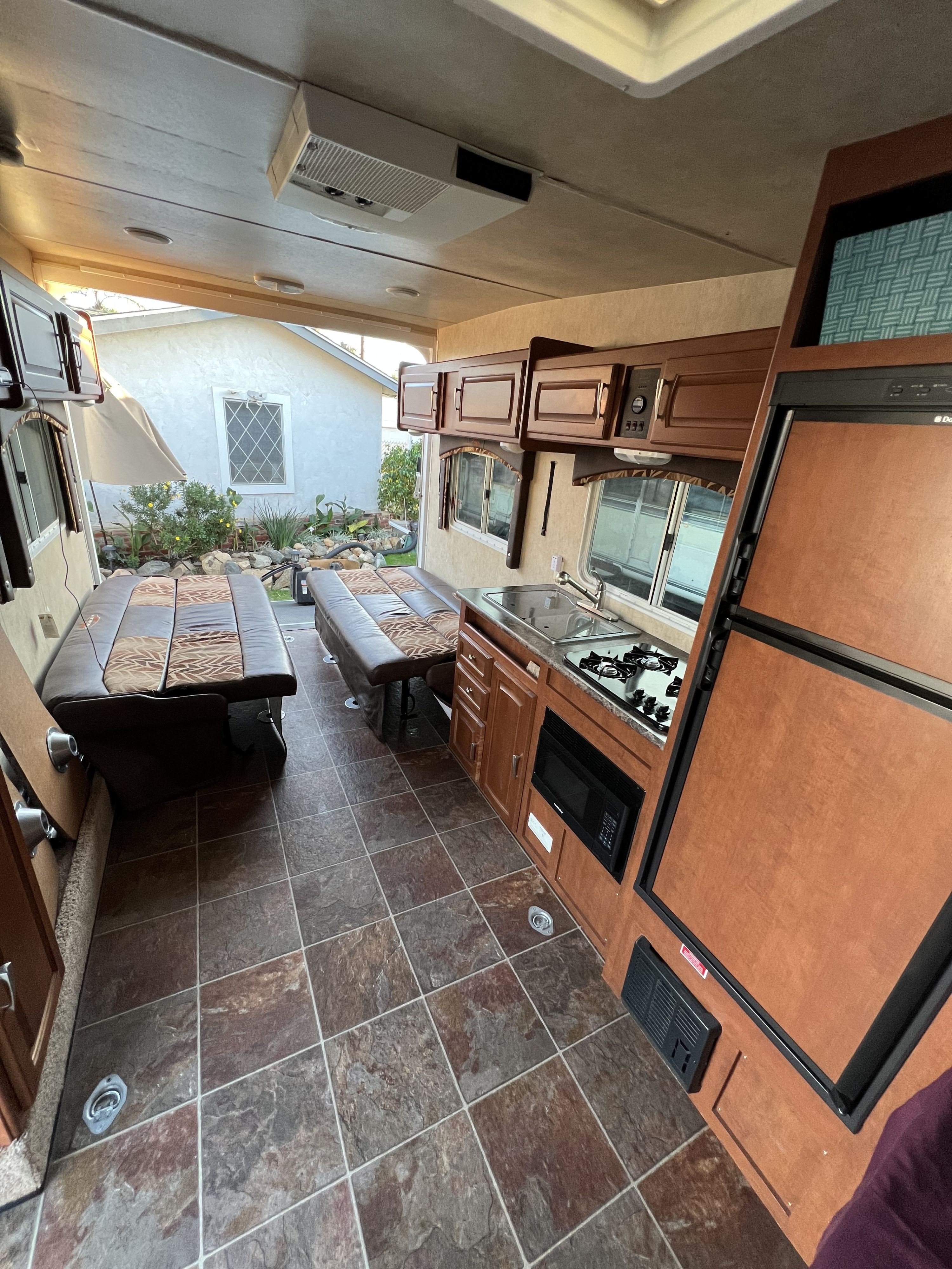Spacious RV rental interior with kitchen, seating, and open rear ramp, perfect for travel adventures.. Forest River Stealth 2012