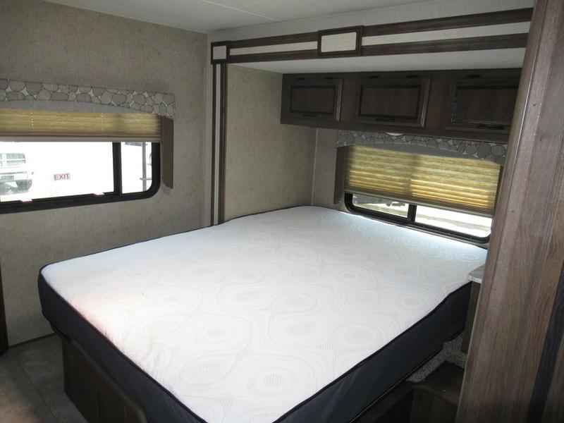 RV rental bedroom: a comfortable mattress, windows with blinds, and ample overhead storage for your travels.. Coachmen Freelander 2019
