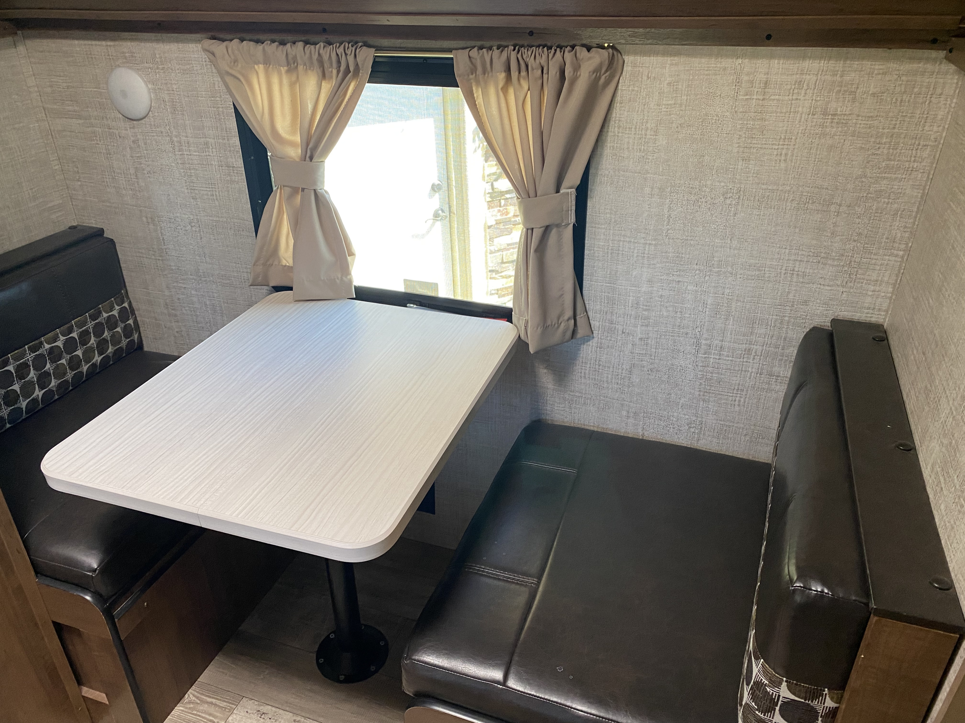 RV rental interior: cozy dinette with booth seating and a table, ideal for meals or relaxing in the camper.. Gulf Stream Trailmaster 2020