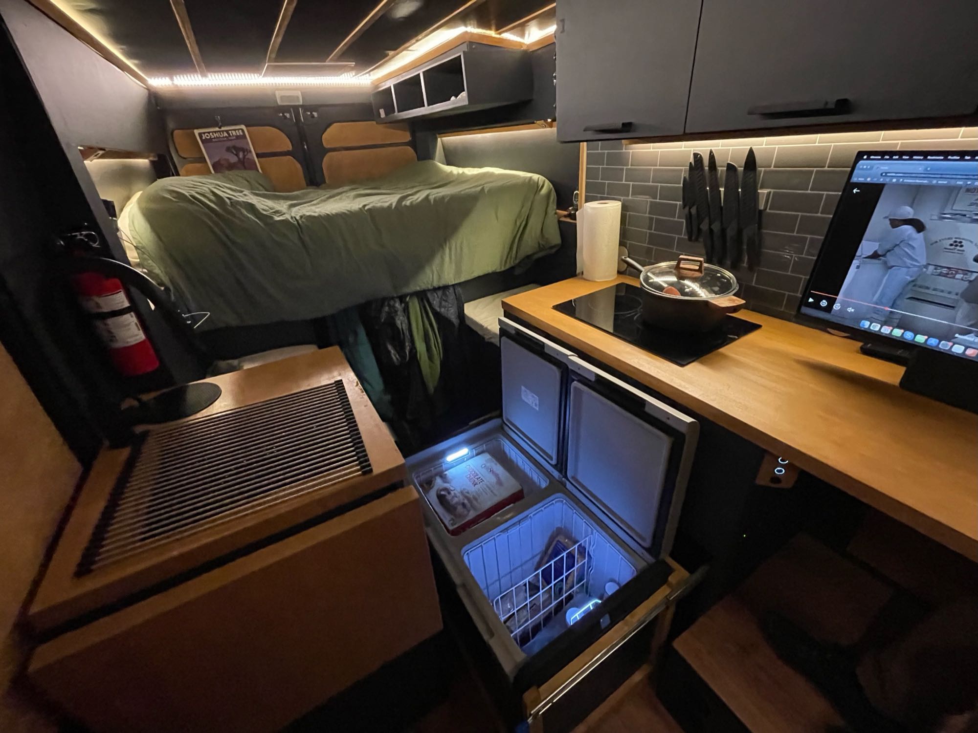 Inside this RV rental: raised bed, modern kitchen with fridge/freezer, cooktop, and storage for your adventures.. Ram Promaster 2021