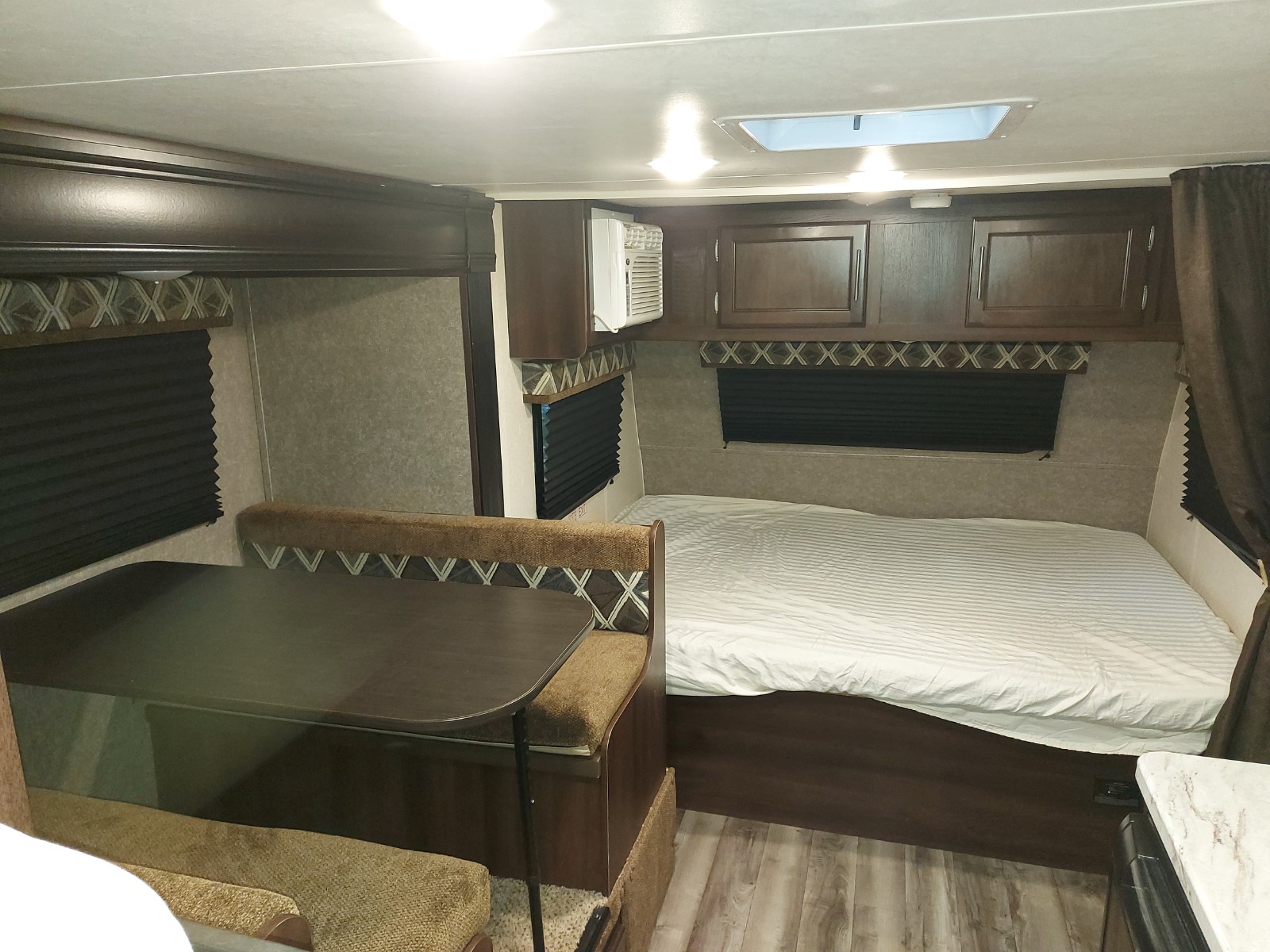 RV rental interior: A cozy bed, convertible dinette, AC unit, and overhead storage provide comfort for your adventures.. Jayco Jay Flight SLX 2019