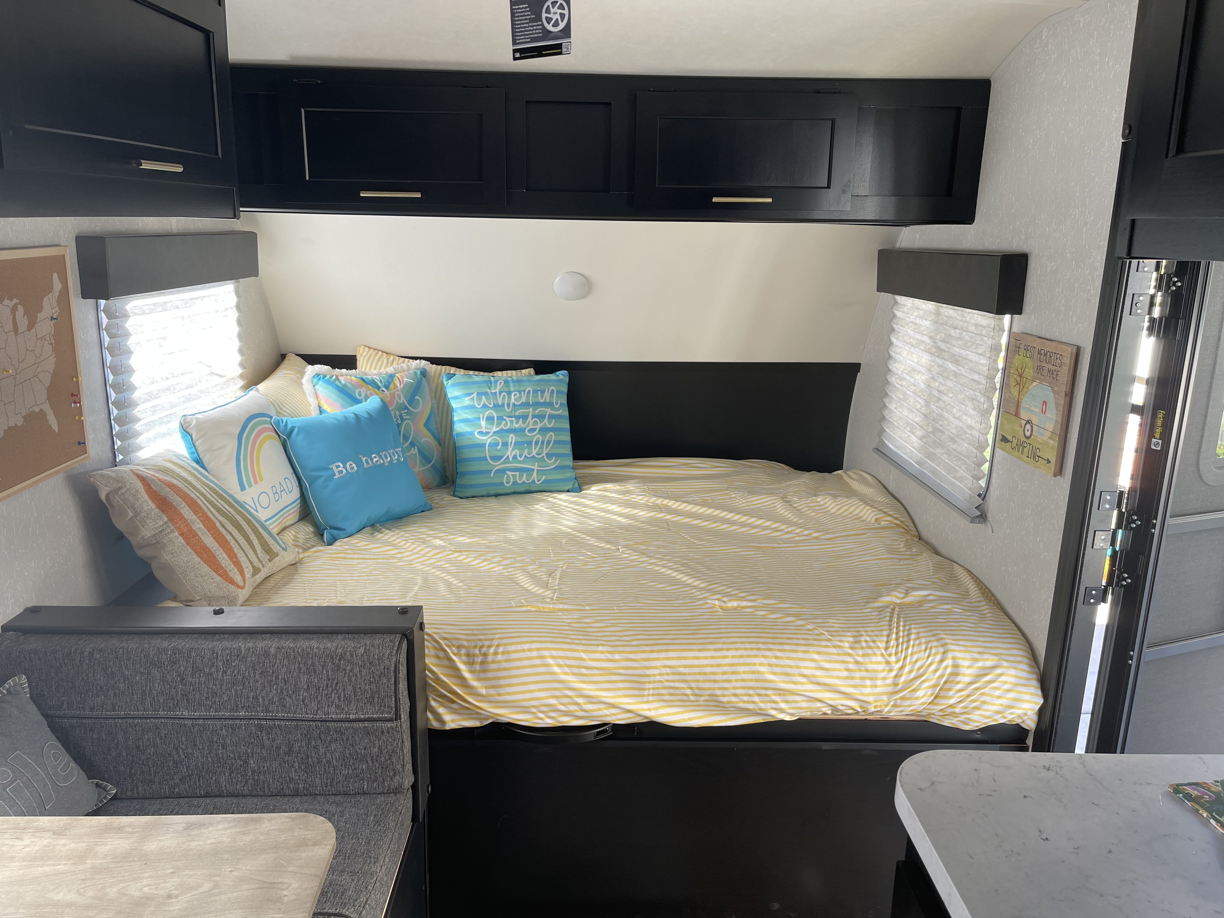 Inviting RV rental bedroom & dinette with a comfy bed, colorful pillows, and smart storage.. Forest River Cherokee Wolf Pup 2022