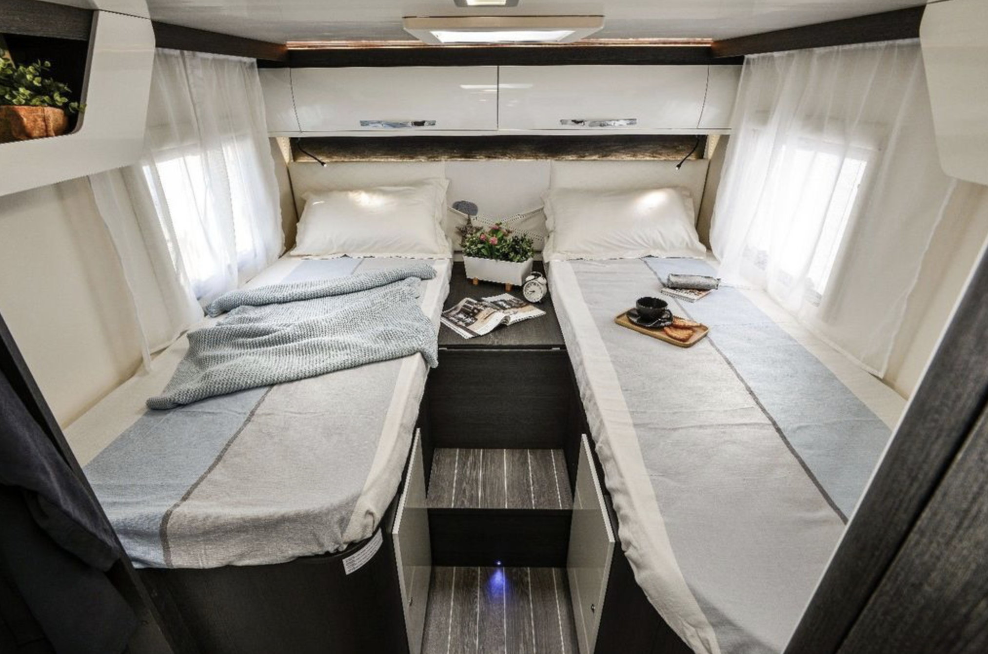RV rental bedroom with two comfortable single beds, a central nightstand, and overhead storage, offering cozy travel space.. Roller Team 685 Zefiro 2022