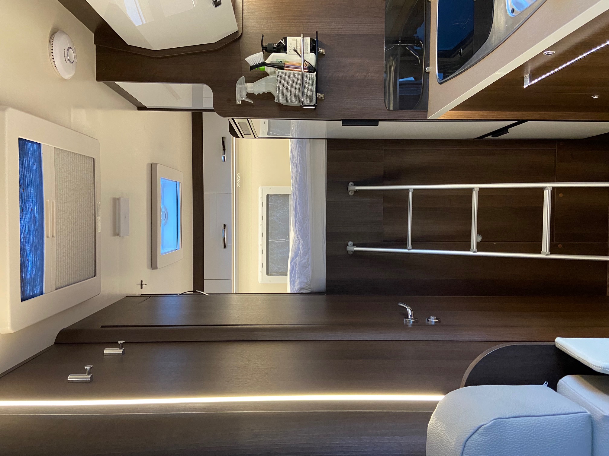 A sleek rv rental interior showcasing a compact kitchenette, storage, ladder to a bed, and bright, functional design.. Ford Rollerteam Zefiro 690 2018