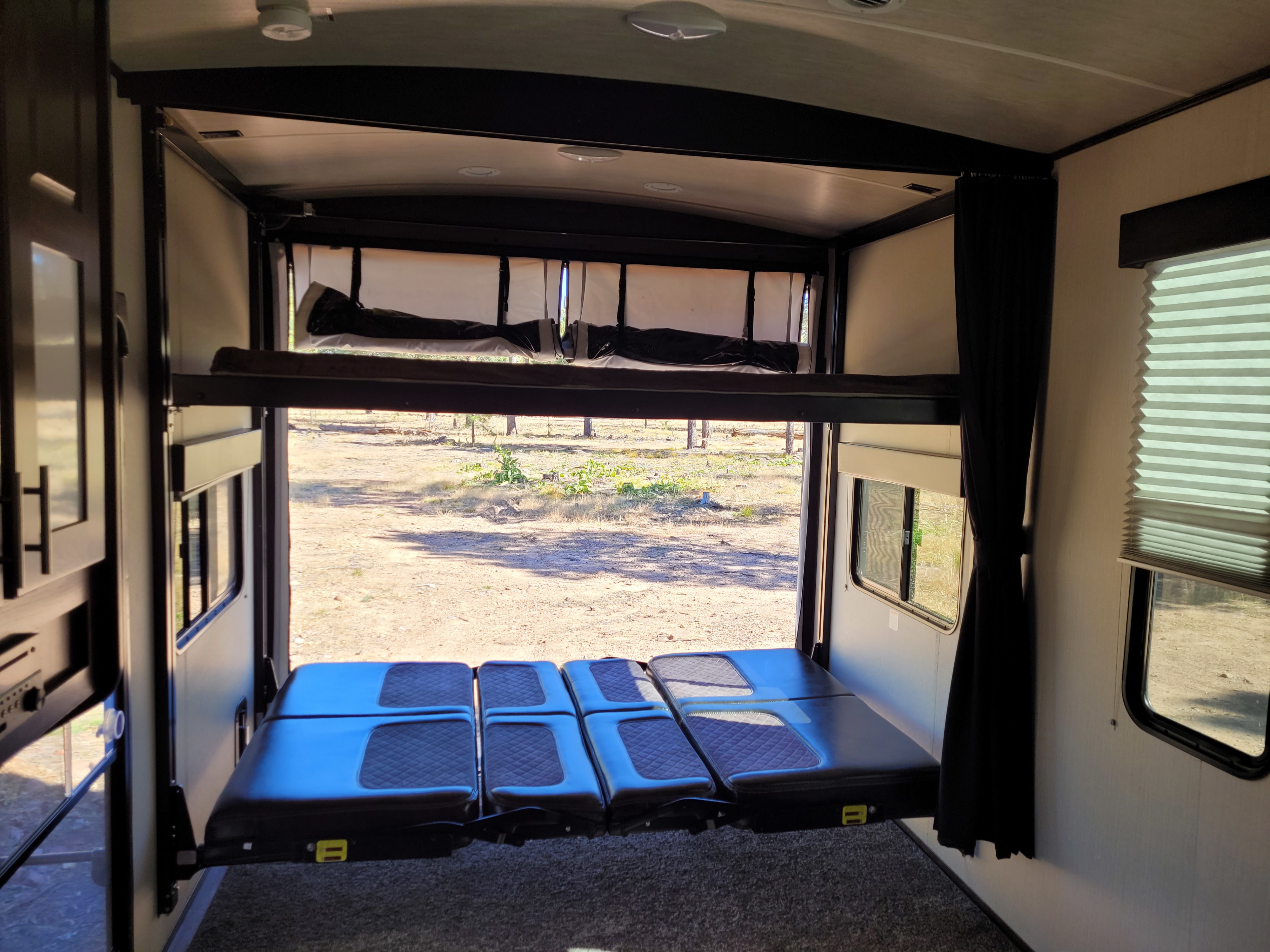 RV rental: Inside a toy hauler with elevated bunk beds & convertible lower seating, offering great views for camping trips.. Heartland Fuel 305 2018