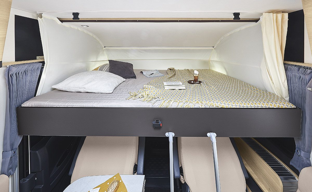 Well-appointed alcove bed in an RV rental, featuring a comfortable sleeping area with soft bedding and lighting.. ITINEO CS660 2022
