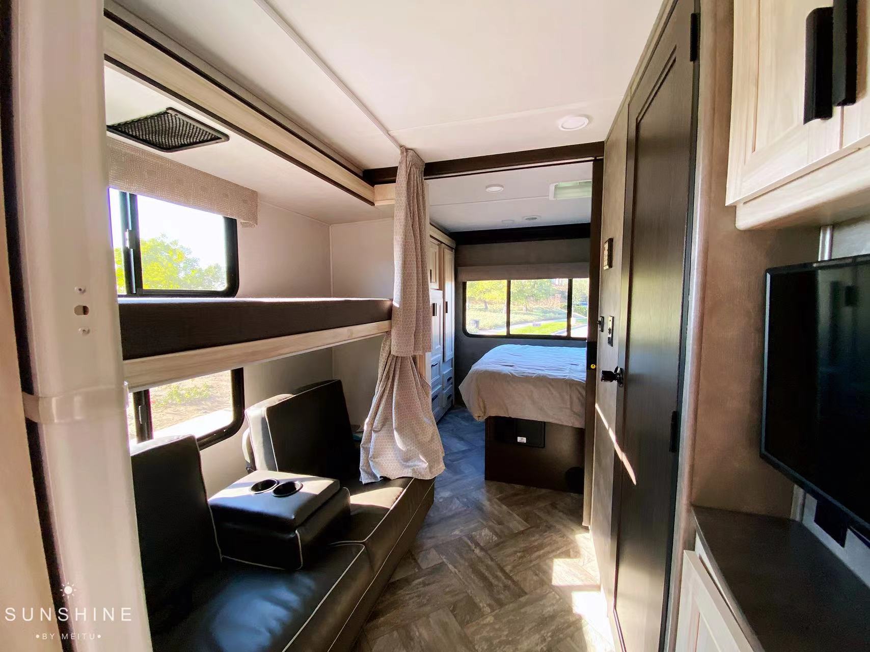 Experience comfort in this **RV rental**: bunk beds, dark seating, and a master bedroom with views.. Forest River Sunseeker 2022