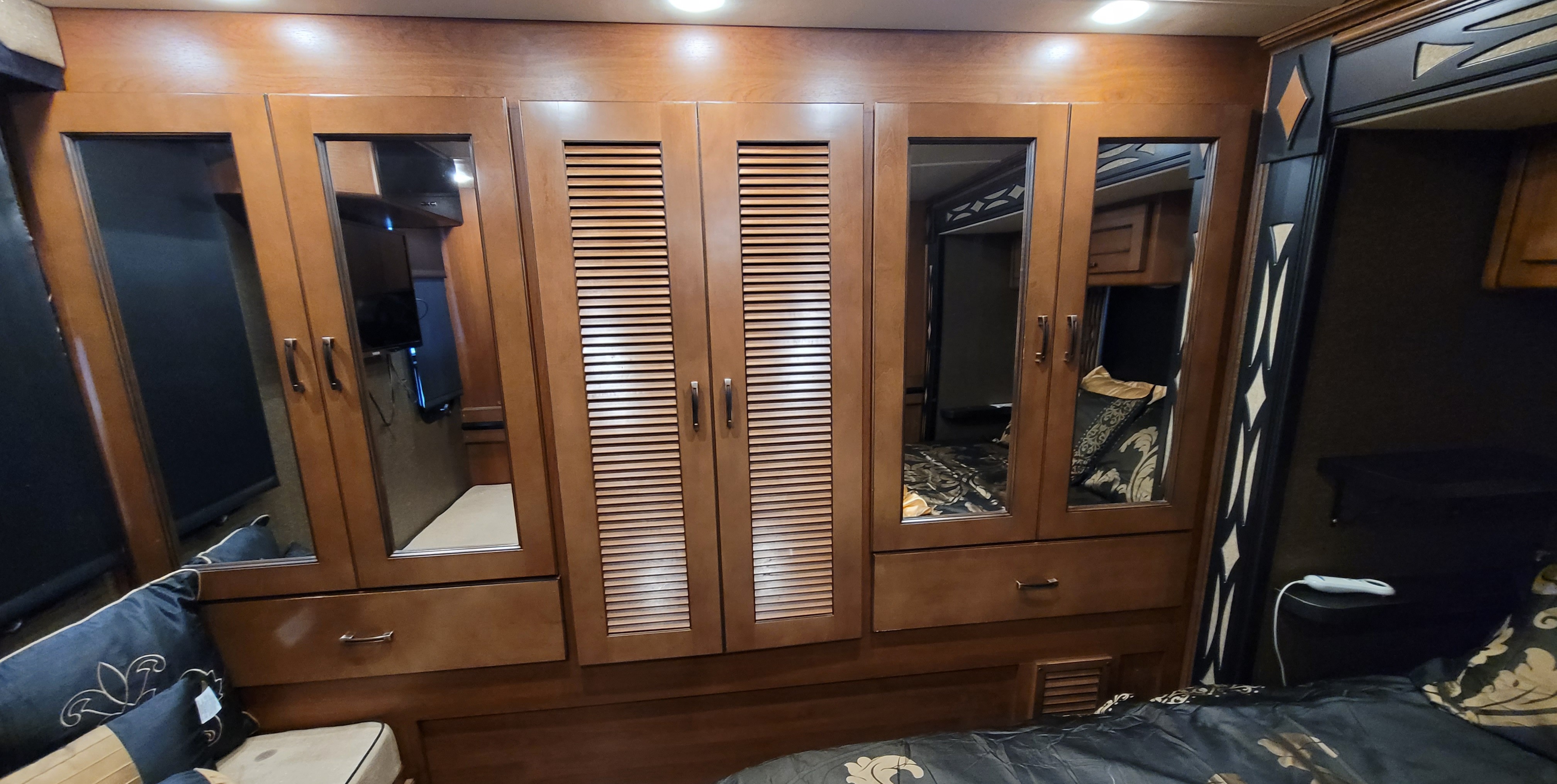 RV rental: Well-appointed RV bedroom featuring a large wood wardrobe with mirrored and louvered doors.. Fleetwood 35E 2015