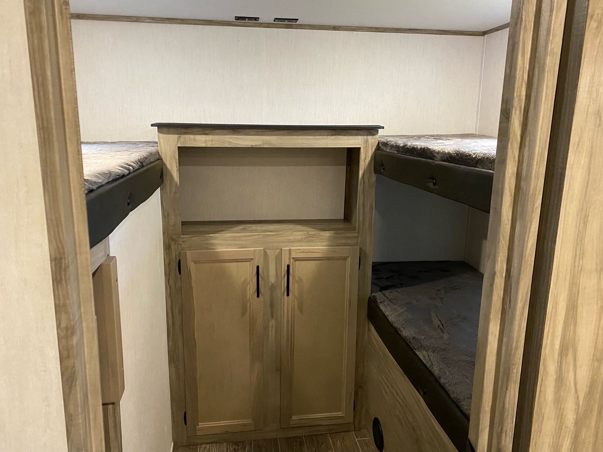 An RV rental bunkhouse featuring multiple bunks and central storage, ideal for family travel.. Forest River Cherokee Alpha Wolf 2021