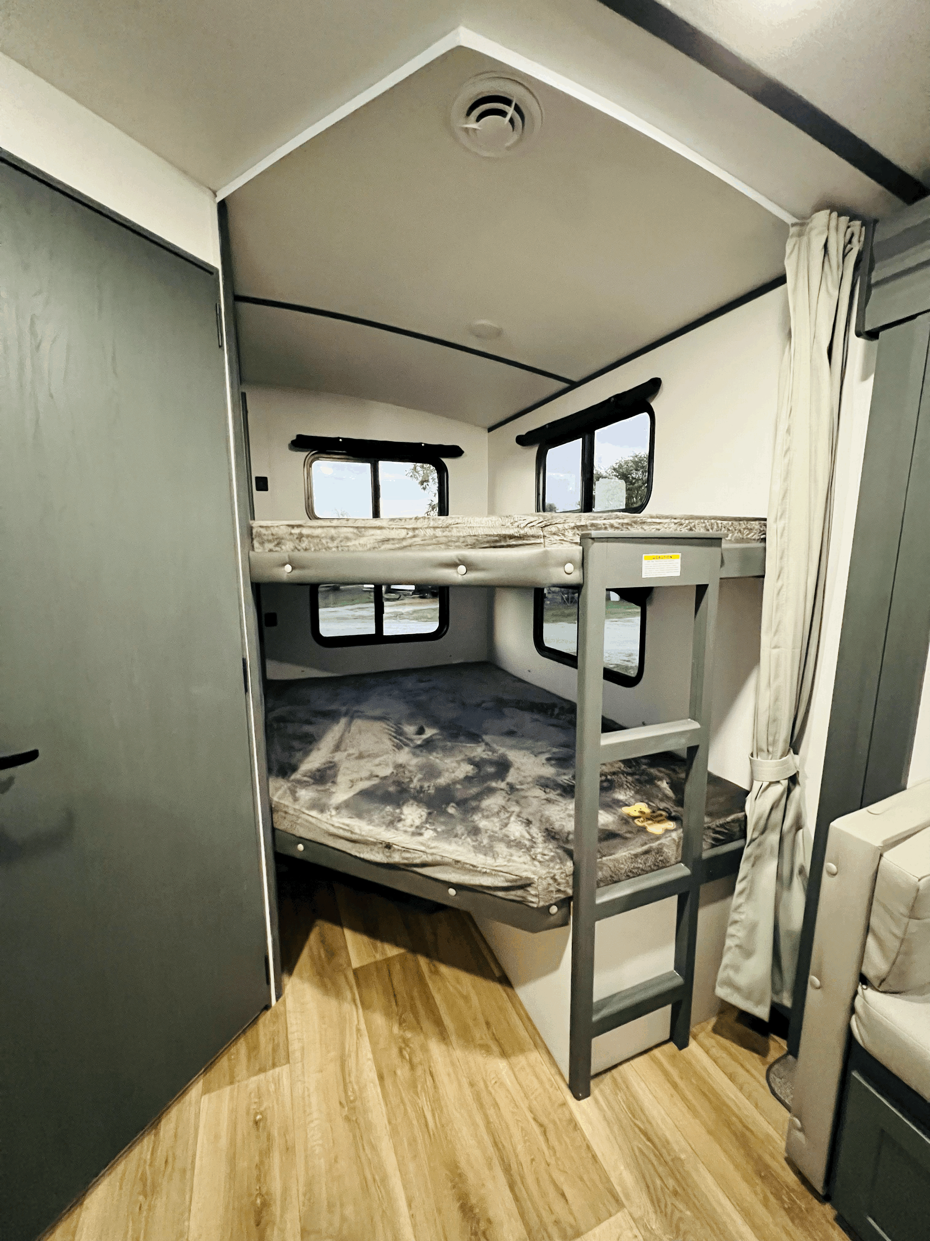 This RV rental features a bright interior with comfy bunk beds, small windows, and a ladder, perfect for family trips.. Keystone Bullet 250BHS 2022