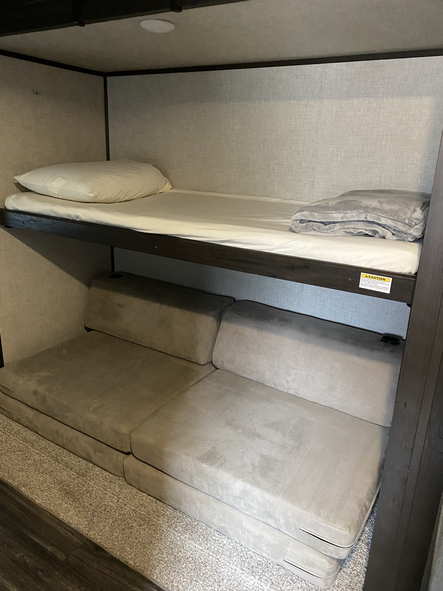 RV rental interior featuring comfortable bunk beds. Top bunk, plus a convertible couch for extra sleeping in a camper.. Keystone RV Bullet Ultra Lite 2021