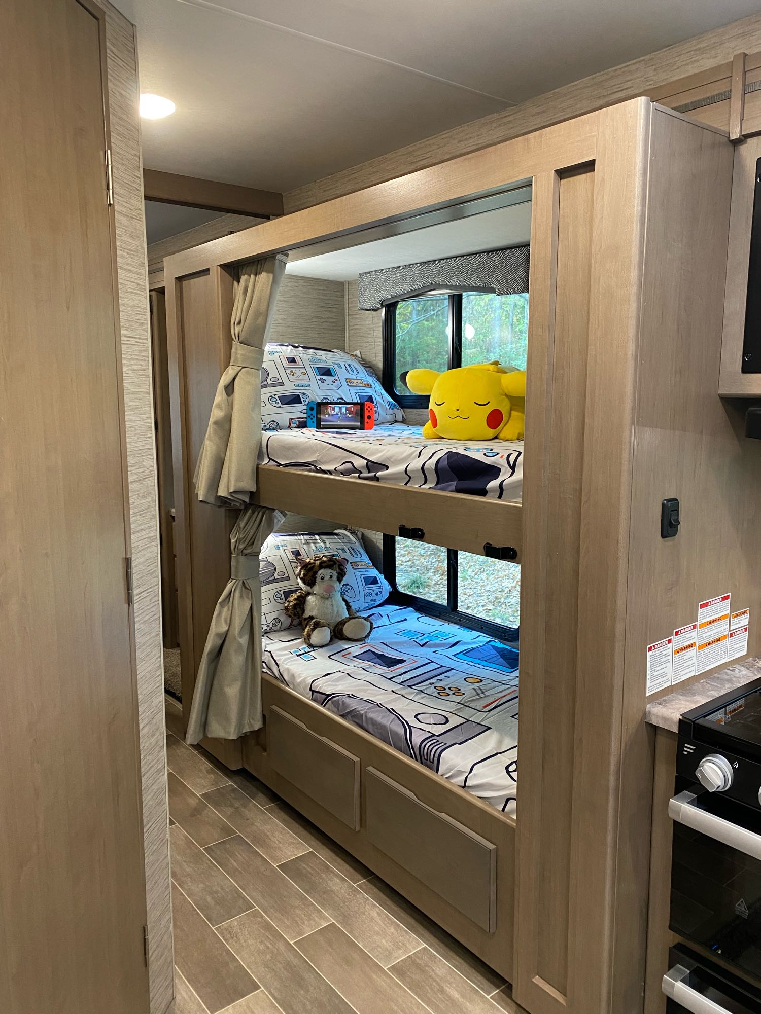 Cozy RV rental bunks, perfect for family adventures, featuring game-themed bedding, a Switch, and plush toys.. Thor Magnitude GA 2022
