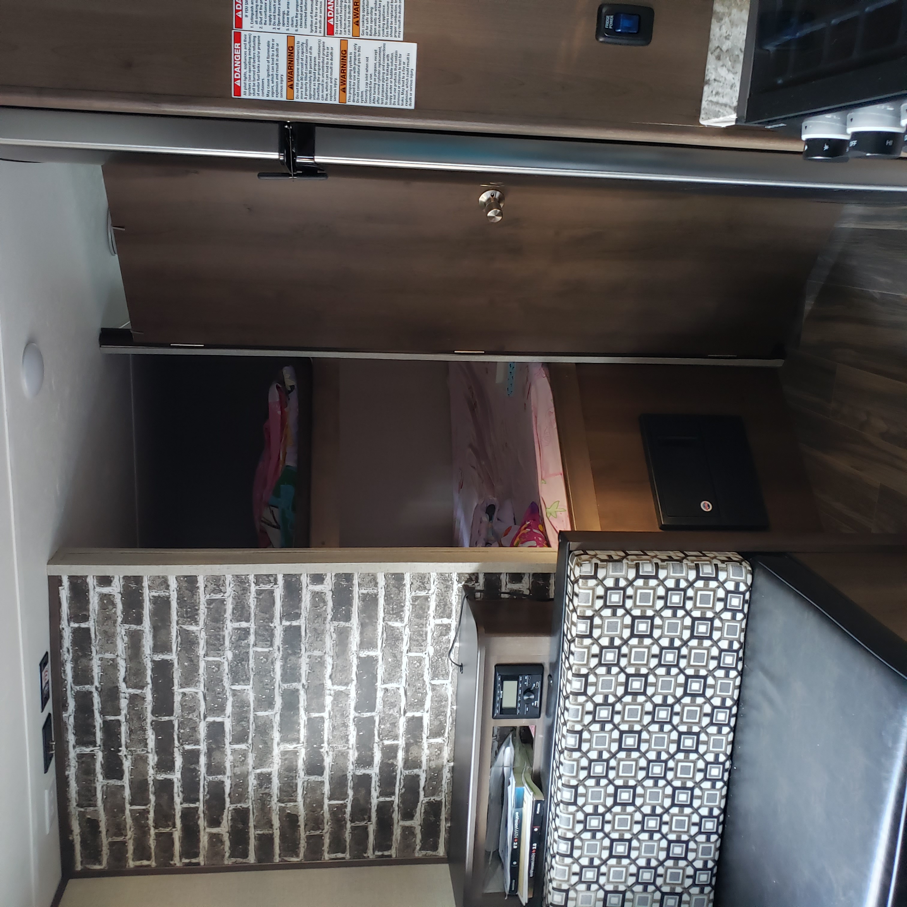 This rv rental's compact interior features a kitchenette, dinette, and bedding. Safety warnings are visible.. Forest River Shasta 2020