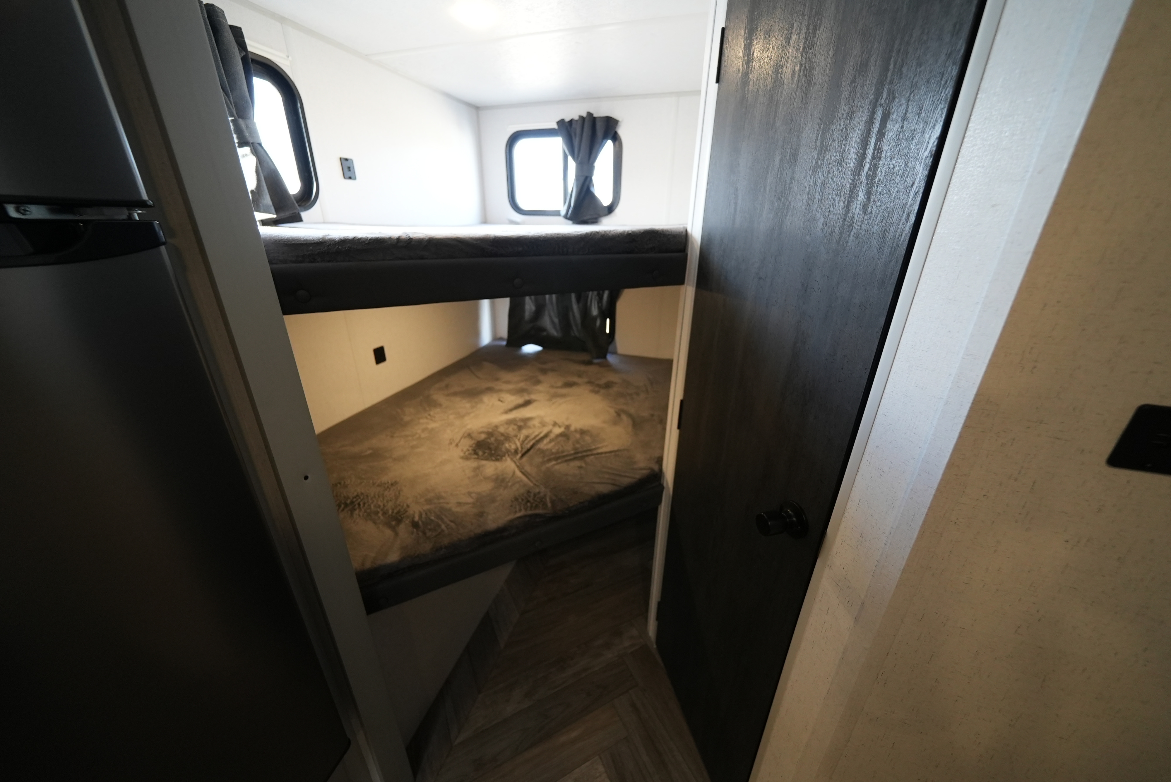 RV rental interior: Cozy bunk beds with windows and dark curtains, perfect for family travel.. Wildwood FSX 178BHsk 2022