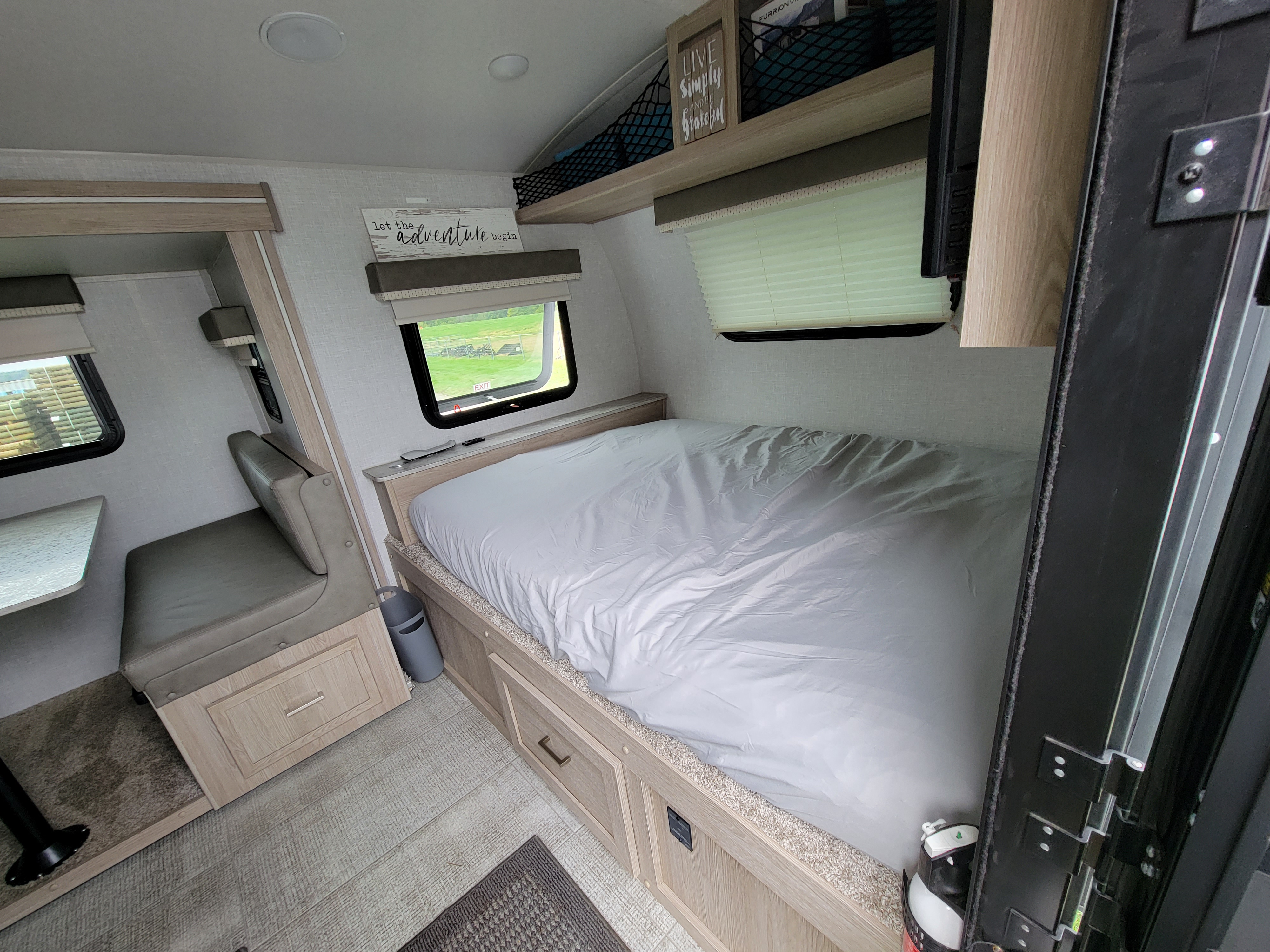 Explore this RV rental's cozy interior, featuring a comfortable bed, dinette, and bright windows.. Forest River Rockwood Geo Pro 2021