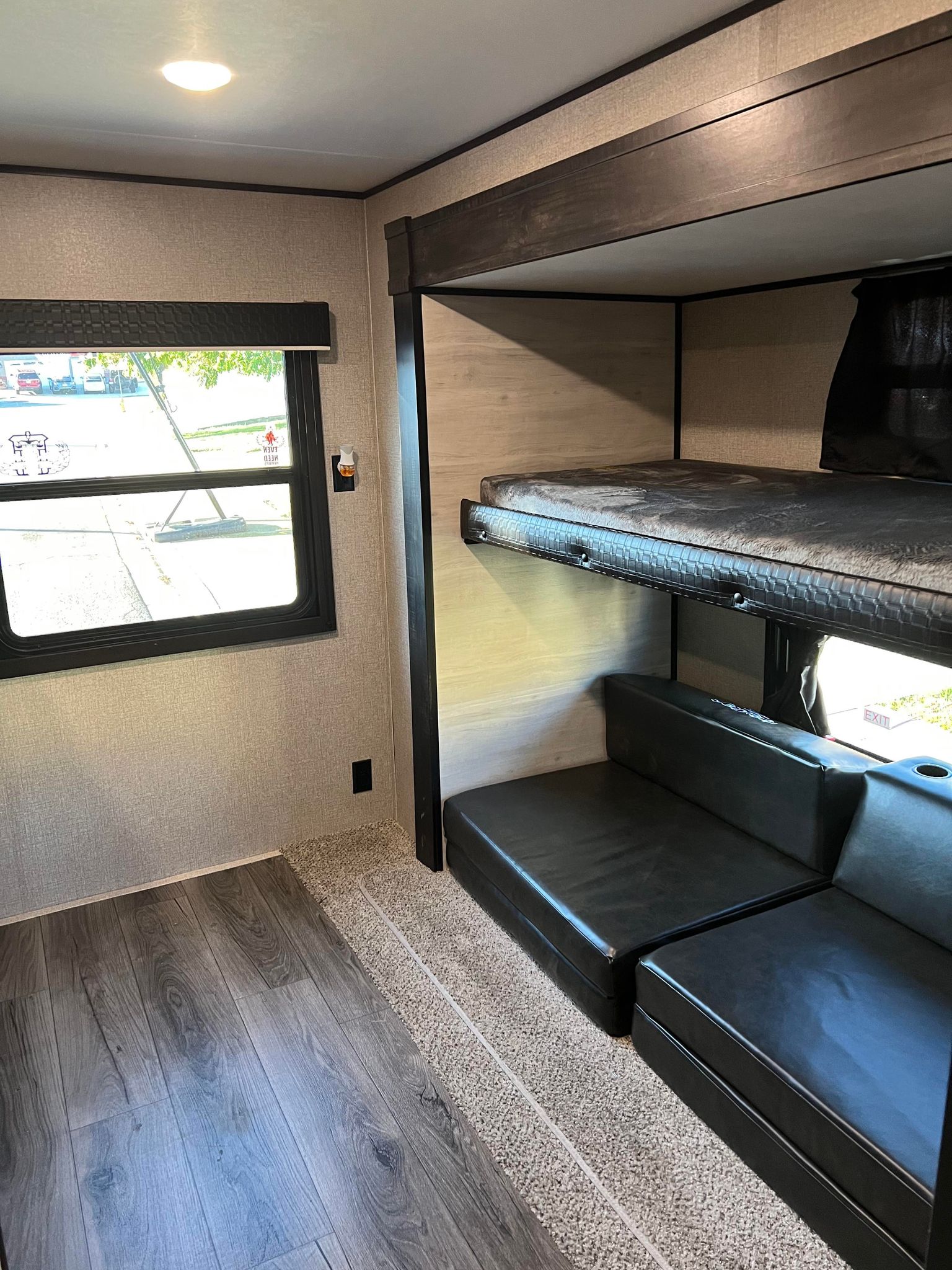 Cozy RV rental interior featuring comfortable bunk beds, a versatile lounge area, and a bright window for mobile living.. Jayco Jay Flight 2021