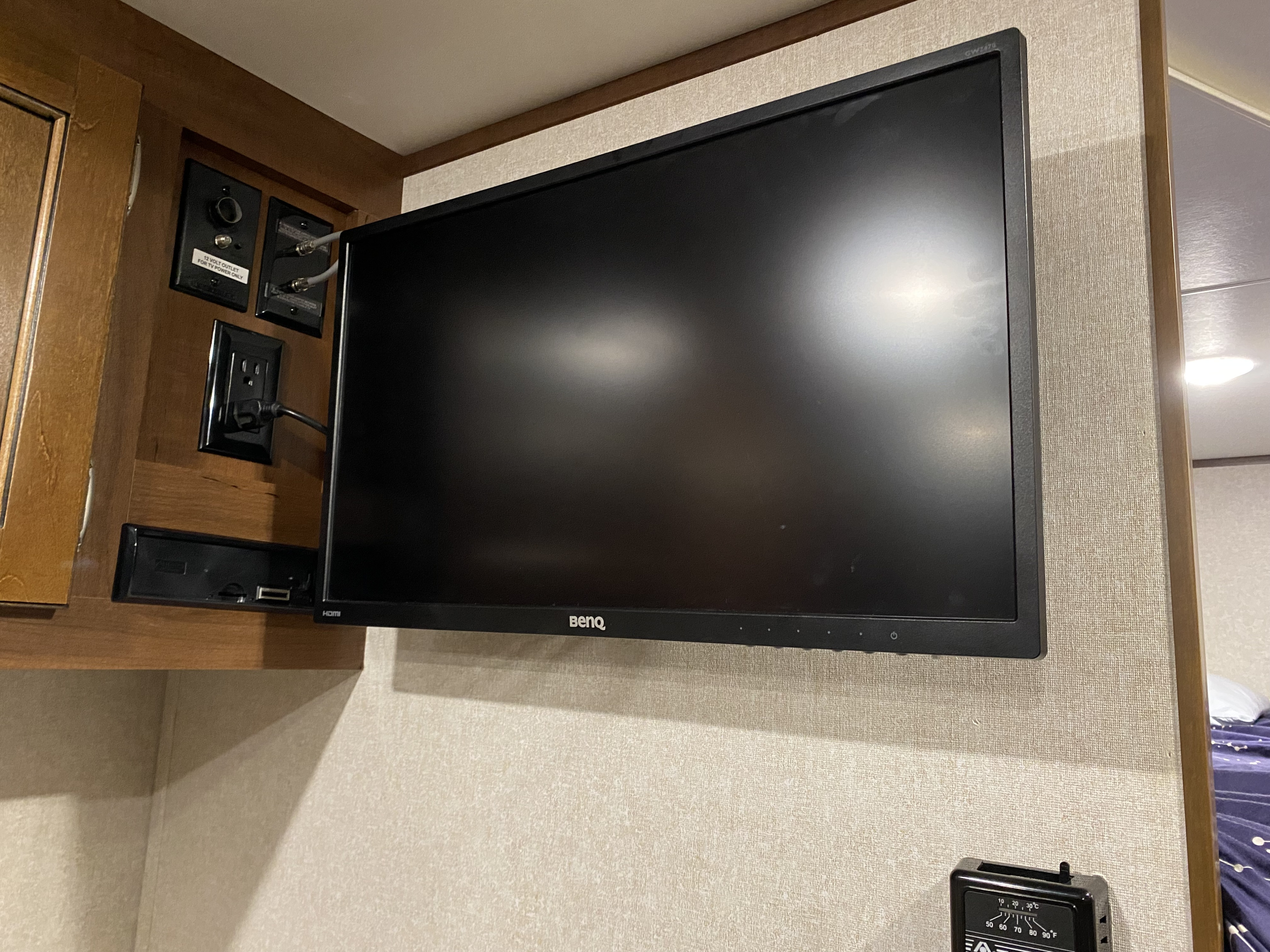 This RV rental shows a wall-mounted Benq TV with dedicated 12V power, standard AC outlet, cable inputs, and a thermostat.. Jayco Jay Flight 2017