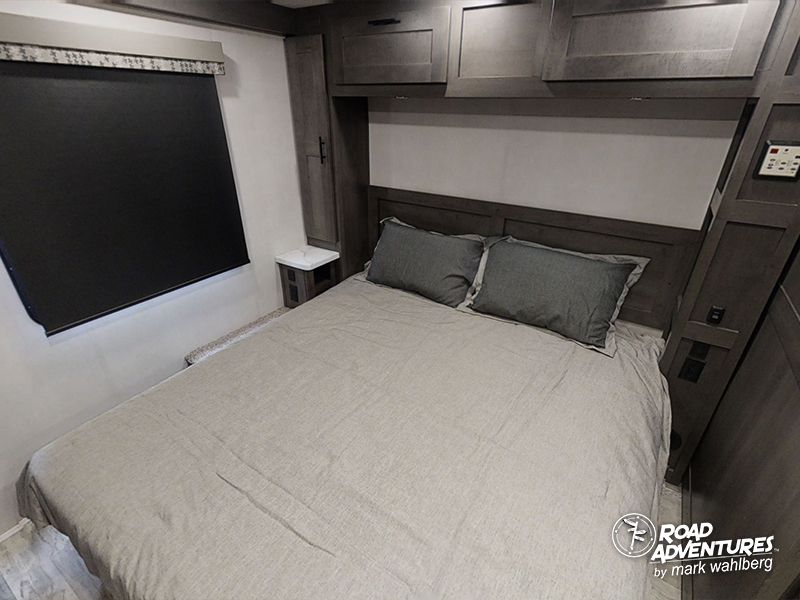 Cozy RV rental bedroom with comfortable bedding, window, nightstand, and overhead storage.. Forest River Fr3 2021