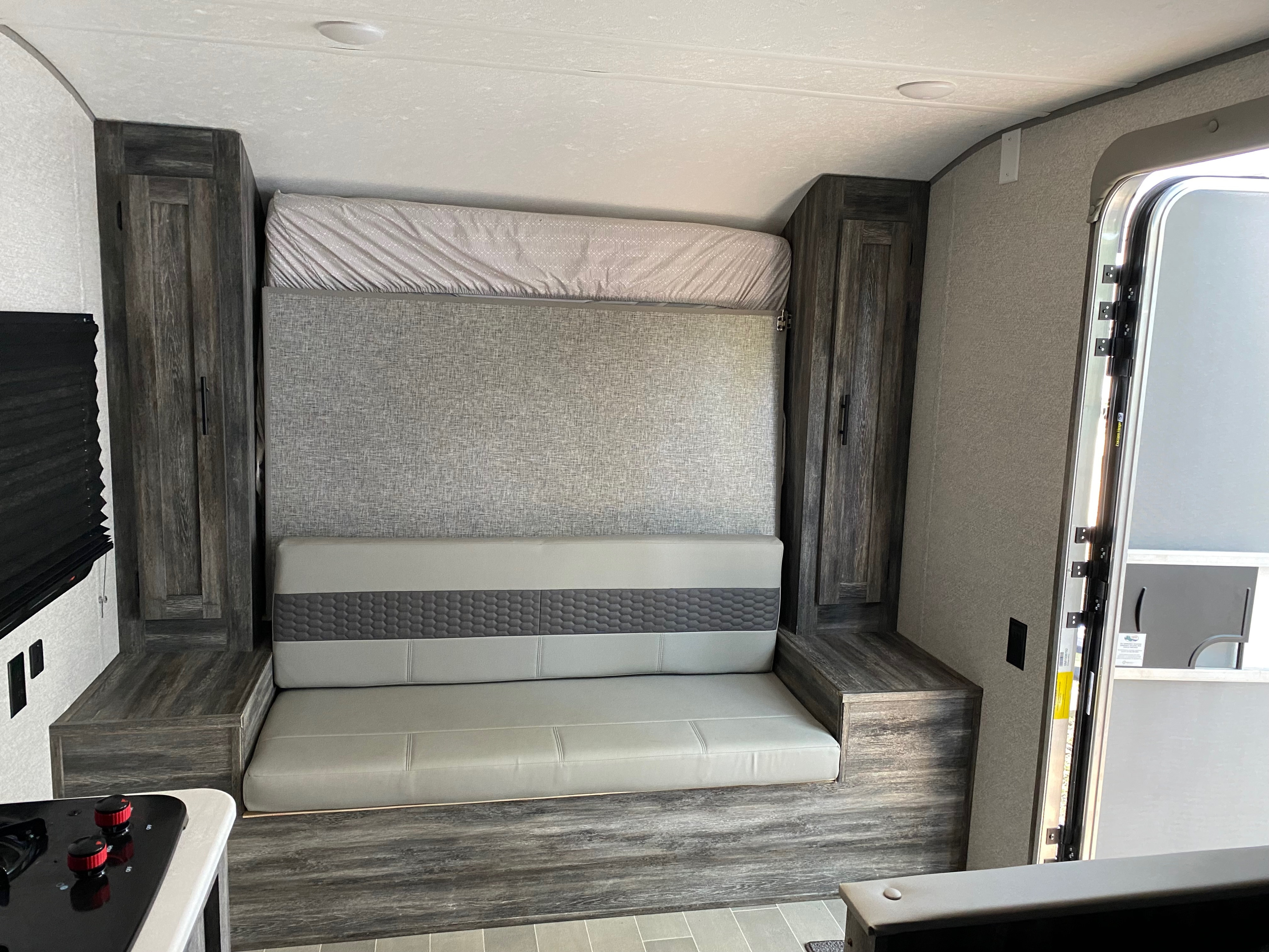 Modern RV rental interior with convertible sofa bed, ample storage, and compact kitchen. Ideal for travel.. Forest River Salem FSX 2021