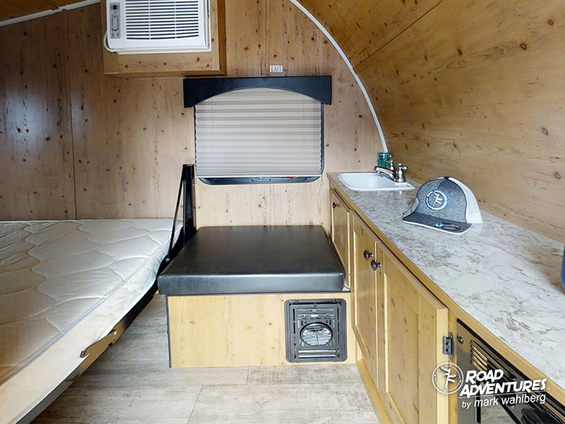 Step inside this RV rental! Features include a comfy bed, bench seating, compact kitchen sink, and AC for your travels.. Sunset Park Sunray 2021