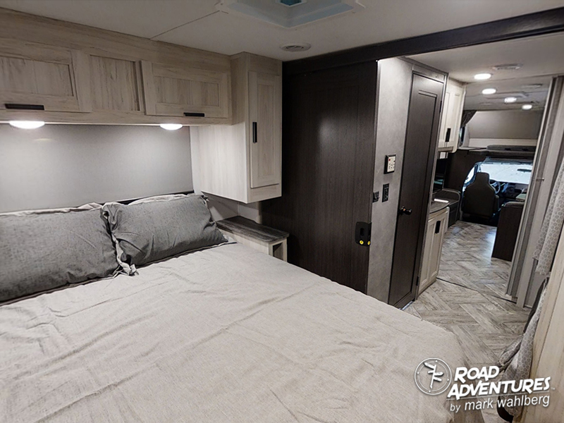 Comfortable RV rental bedroom interior with modern design, leading to the motorhome cockpit. Ideal for travel.. Forest River Sunseeker 2022