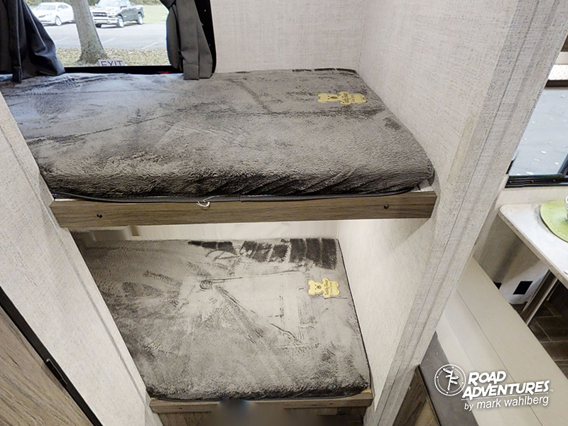 Cozy RV rental bunk beds with grey blankets & teddy bears, providing comfortable sleeping areas for your adventure.. Gulf Stream Amerilite 2021