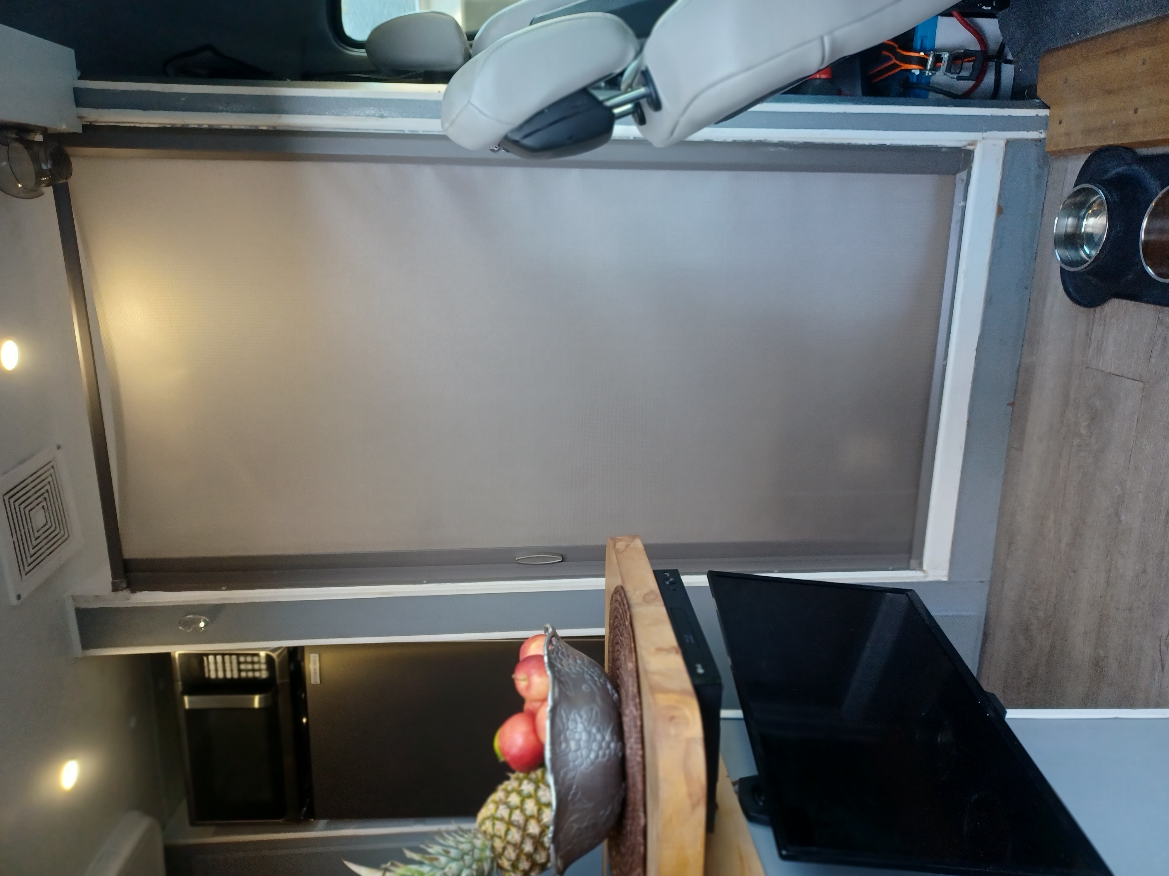 RV rental interior: large window blind, front seats, TV, fruit bowl, and pet bowls on the floor.. Mercedes Benz Mercedes Benz Sprinter Van Conversion 2012
