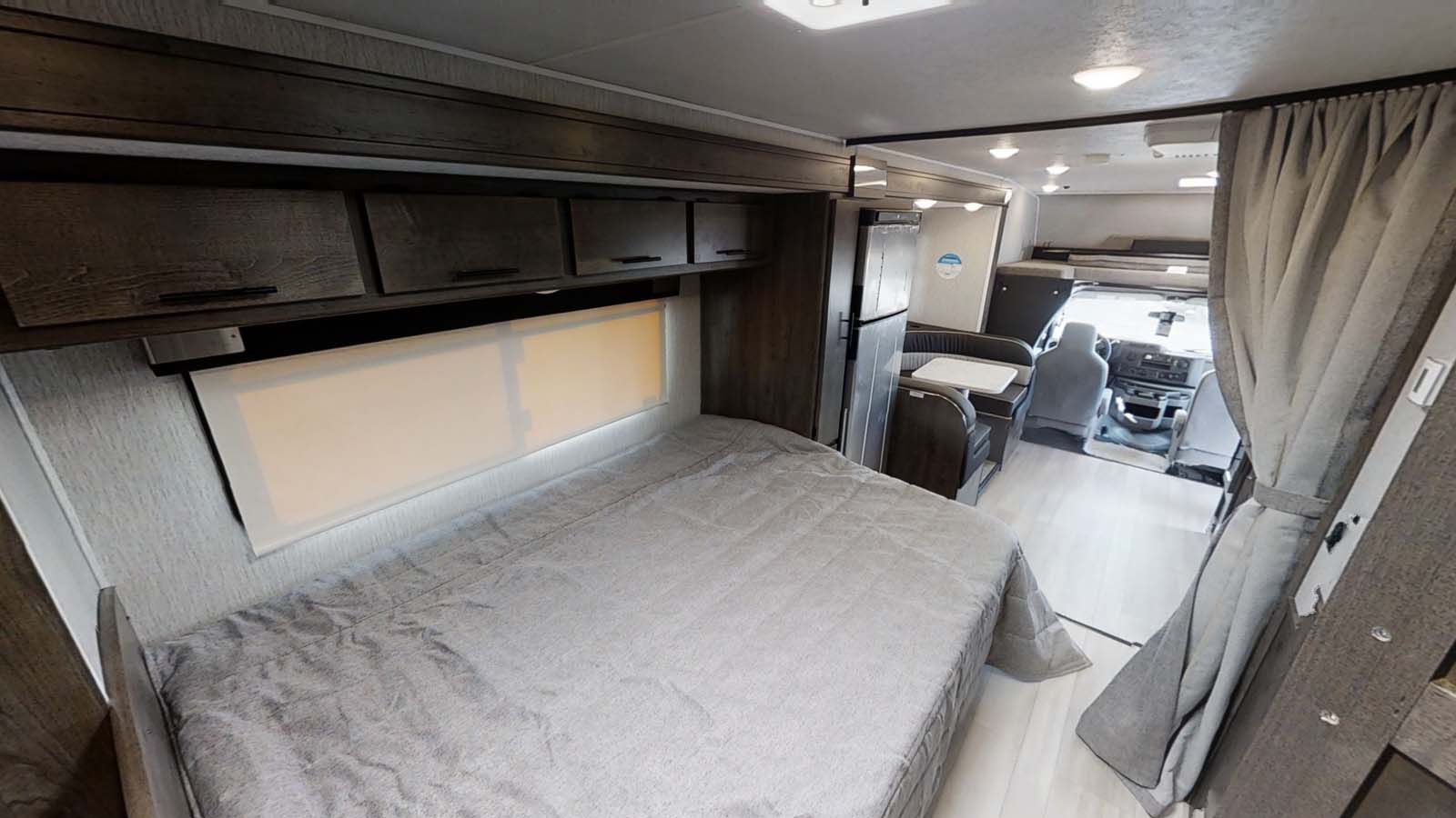 Experience comfort in this RV rental. Full interior view showing a cozy bed, dinette, kitchen, and front cockpit.. Forest River Coachmen Leprechaun 2021