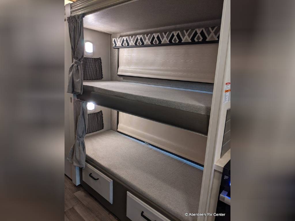 Cozy RV rental bunk beds for family adventures. Each bunk has a light, shade & storage, perfect for travel.. Jayco Greyhawk 2022