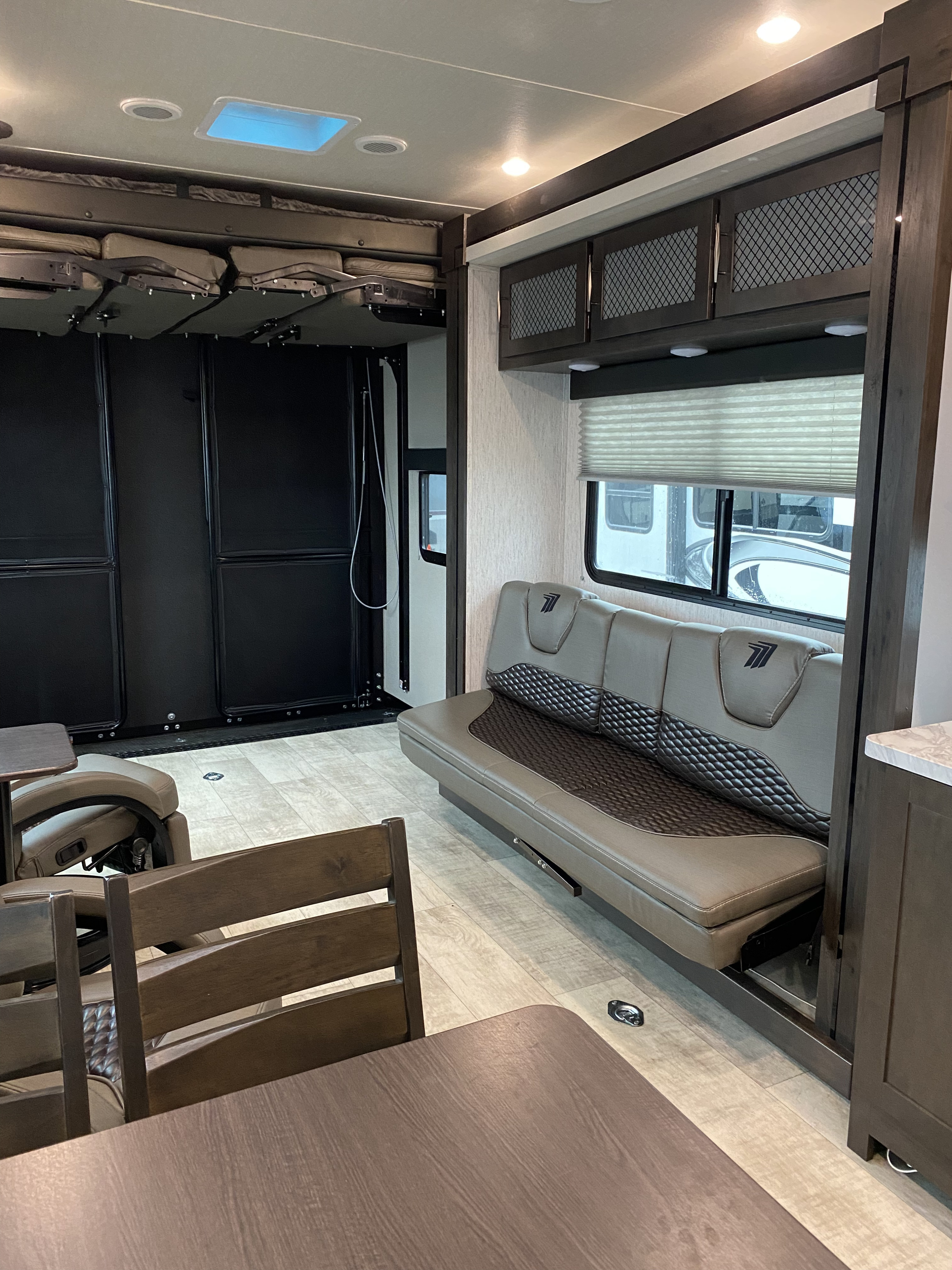 RV rental interior: Spacious toy hauler with convertible sofa bed, bunks, and dining area, ready for adventure.. Grand Design Momentum 2021