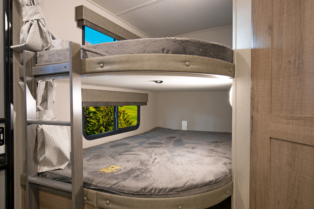 Cozy RV rental interior featuring comfortable bunk beds with windows, perfect for family adventures on the road.. Grand Design Imagine 2021
