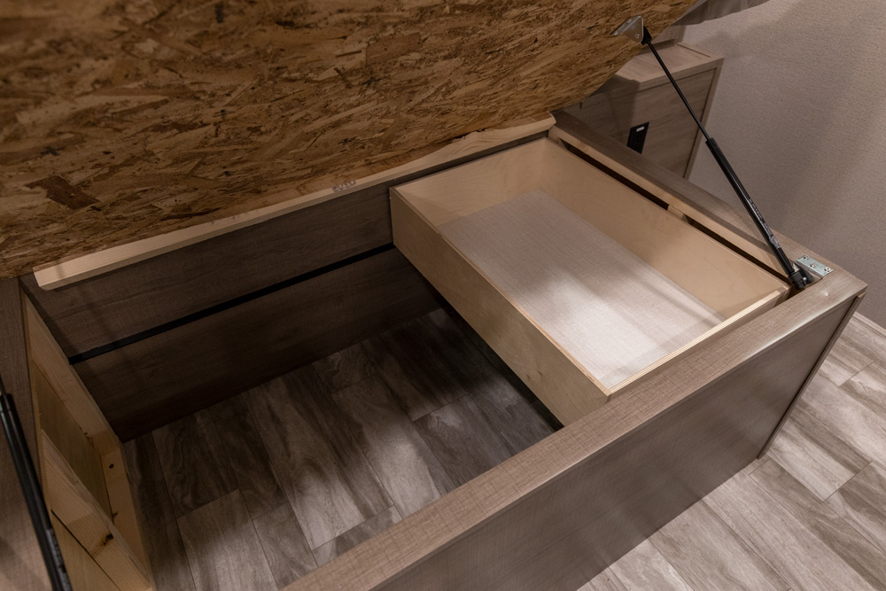 Efficient RV rental storage features under-bed access, a pull-out drawer, and a deep compartment for organized living.. Grand Design Imagine 2021