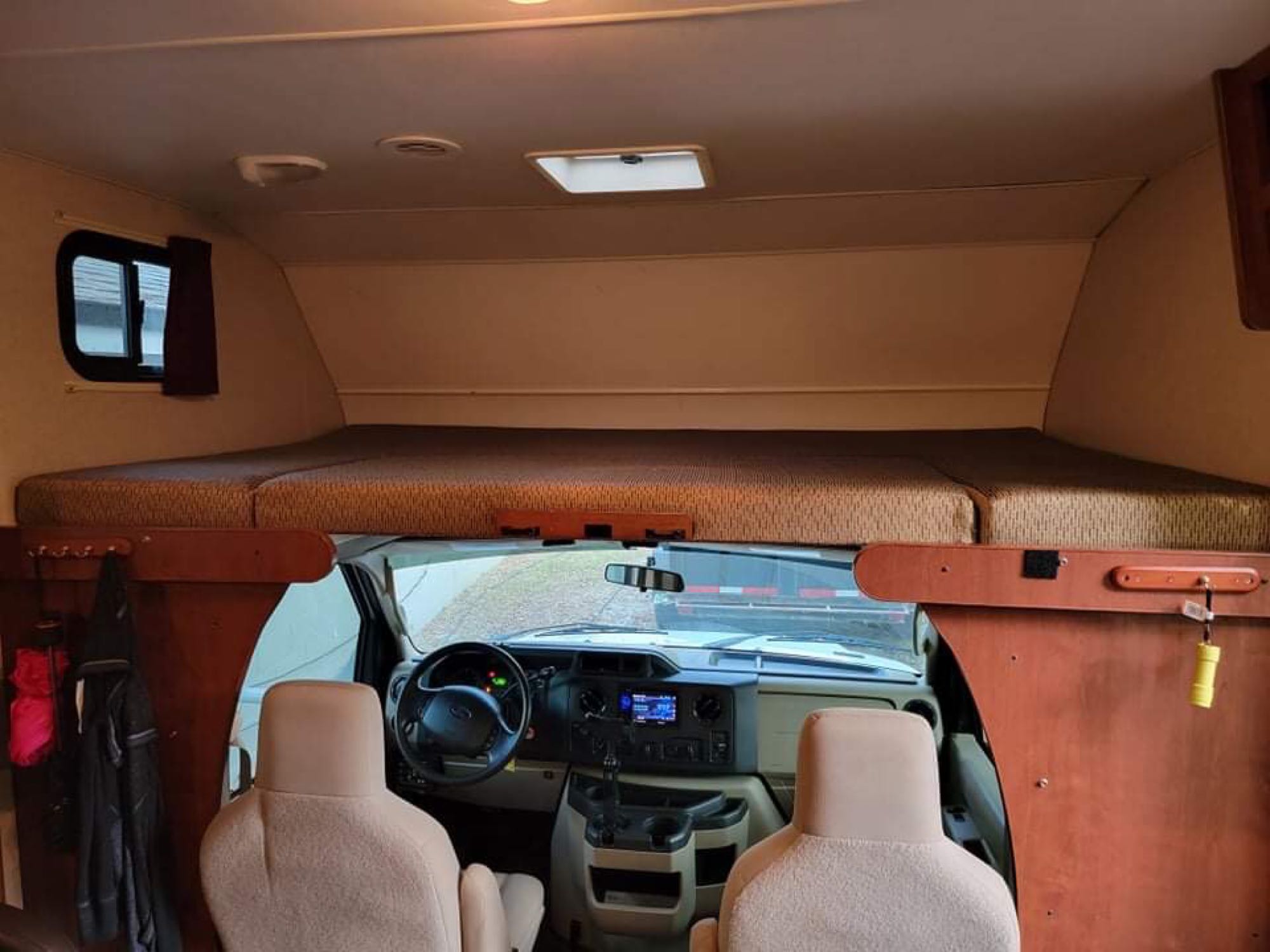 RV rental interior, featuring the cozy bed above the driver's cab and front seats. Ready for adventure!. Winnebago Minnie Winnie 2014