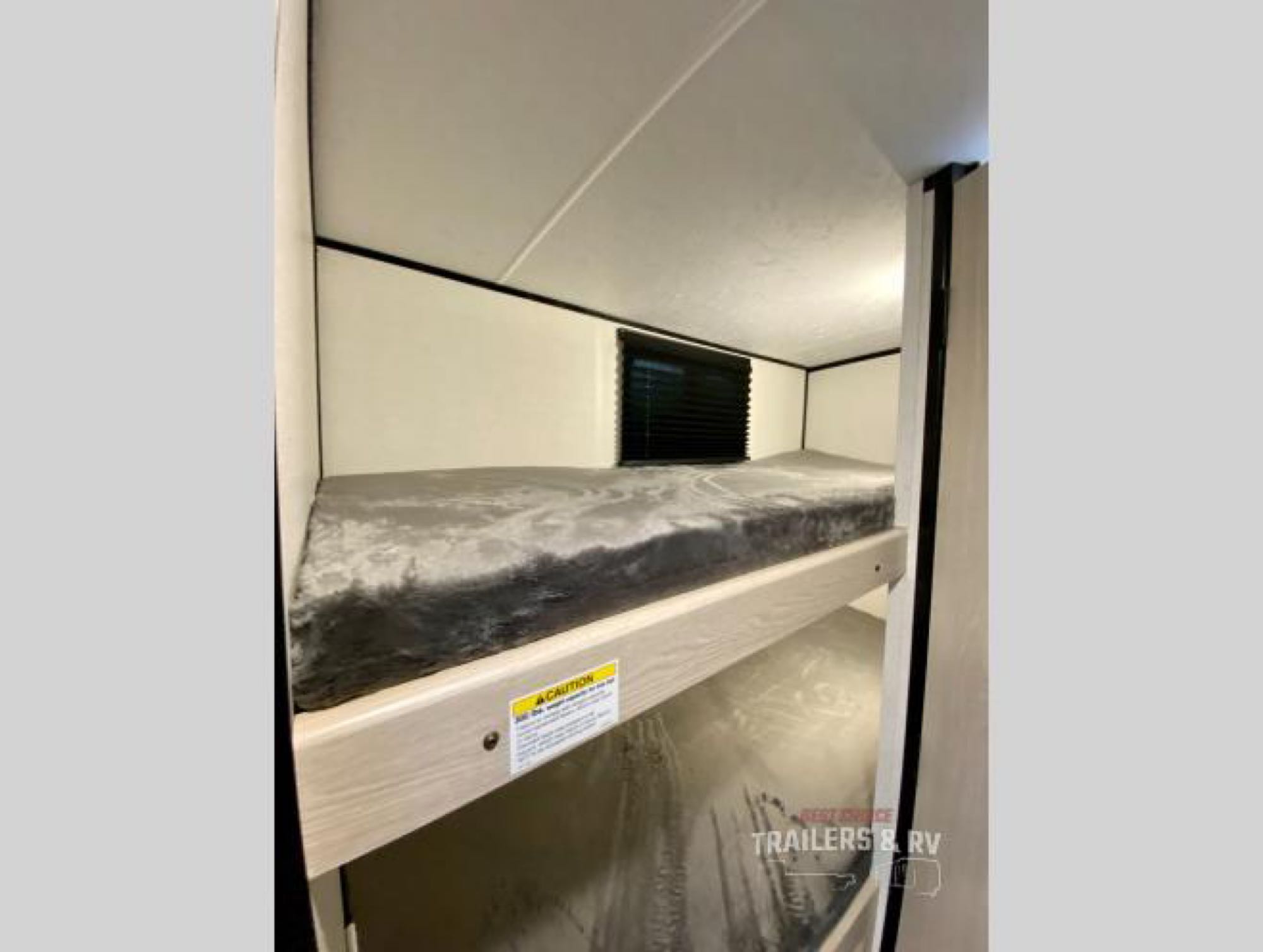 This RV rental offers practical sleeping with cozy bunk beds. Features include a top bunk with a mattress and a lower sleeping space, ideal for families.. Coachmen Apex 2022