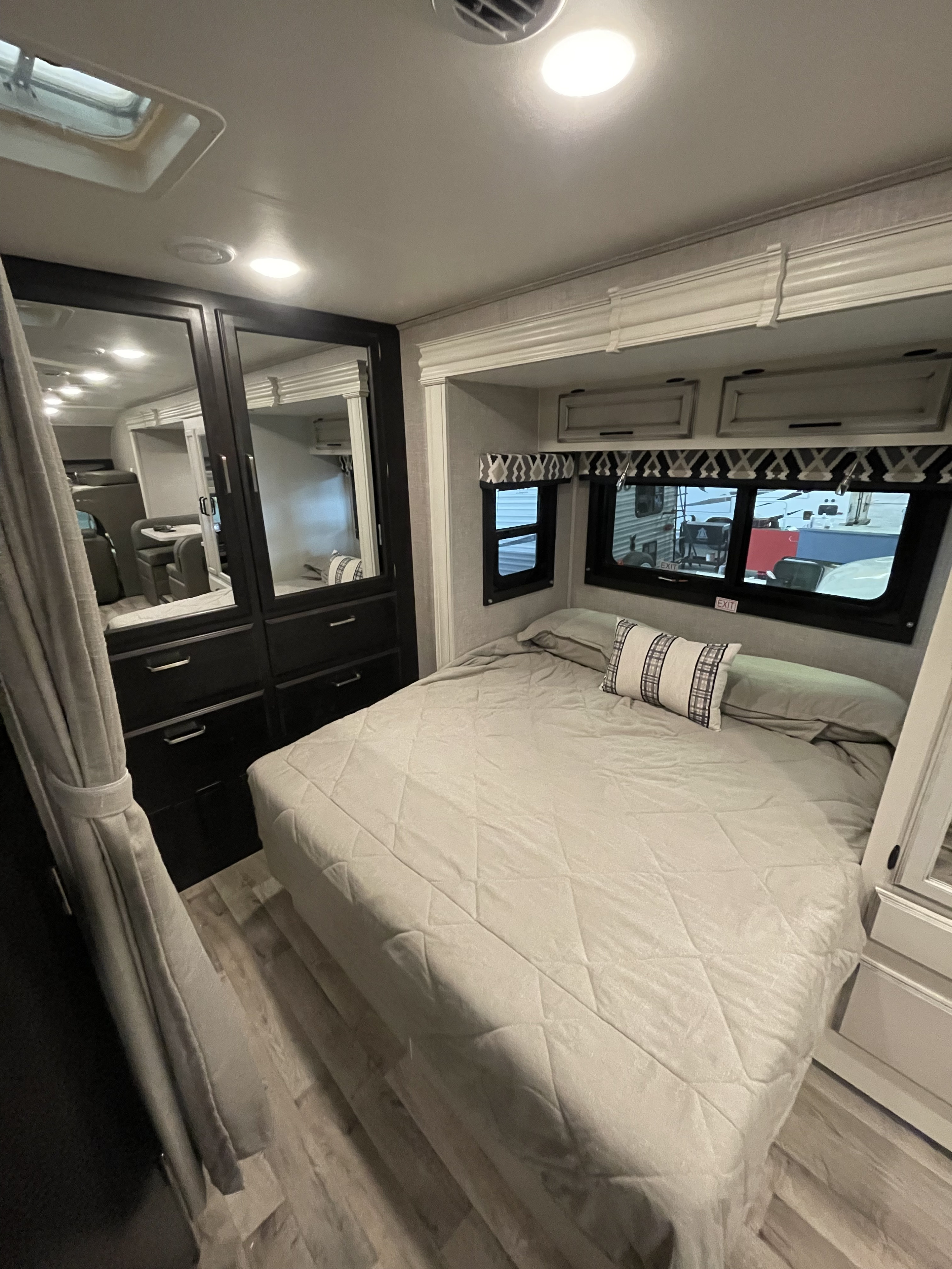 RV rental bedroom interior: cozy bed, built-in storage, and bright windows offer a comfortable, compact space for travel.. Jayco Redhawk 2021